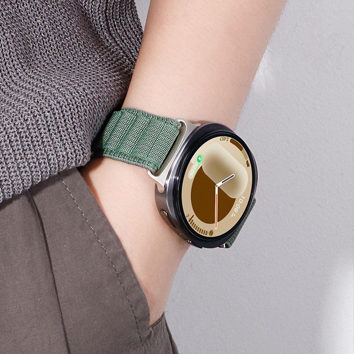 Handgelenk mit Smartwatch. Die Uhr hat ein grünes Armband. Die Uhrzeit ist 10:09.