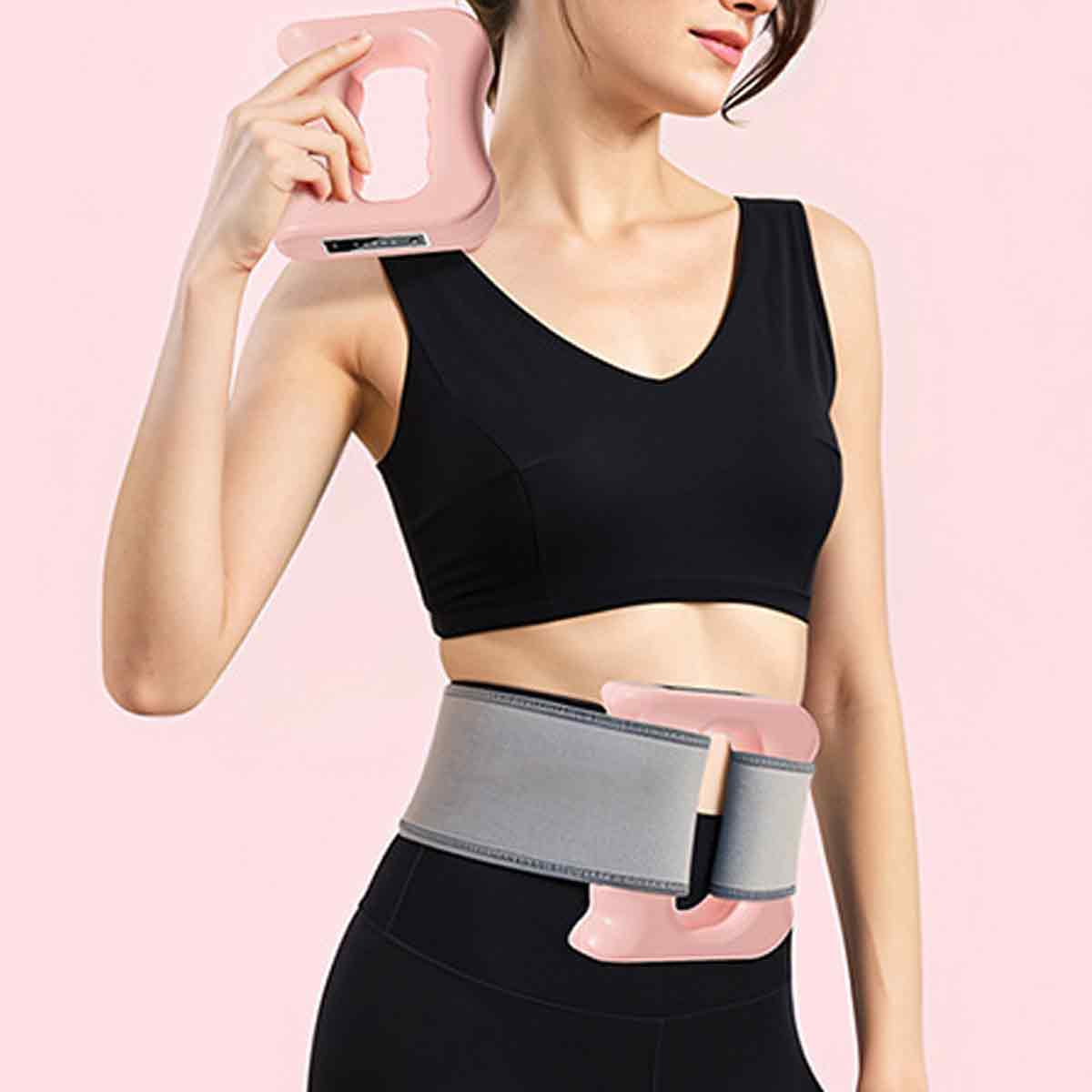 Frau in schwarzem Sport-BH und Leggings hält ein rosa Massagegerät an Hals und Taille vor rosa Hintergrund.