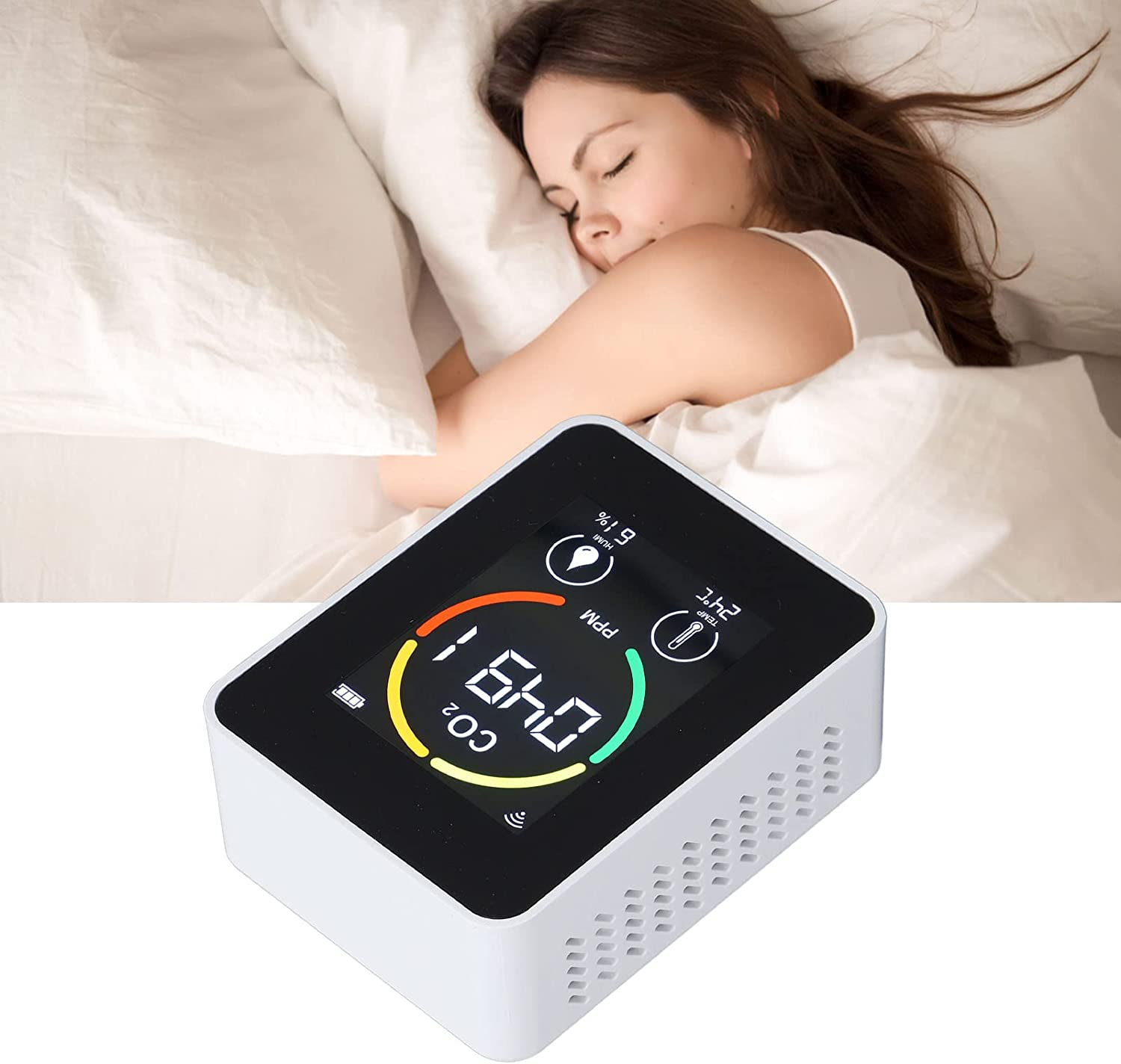 Eine Frau schläft im Bett mit weißem Kissen und Laken. Ein weißes Gerät zeigt CO2-Werte und Temperatur im Vordergrund an.