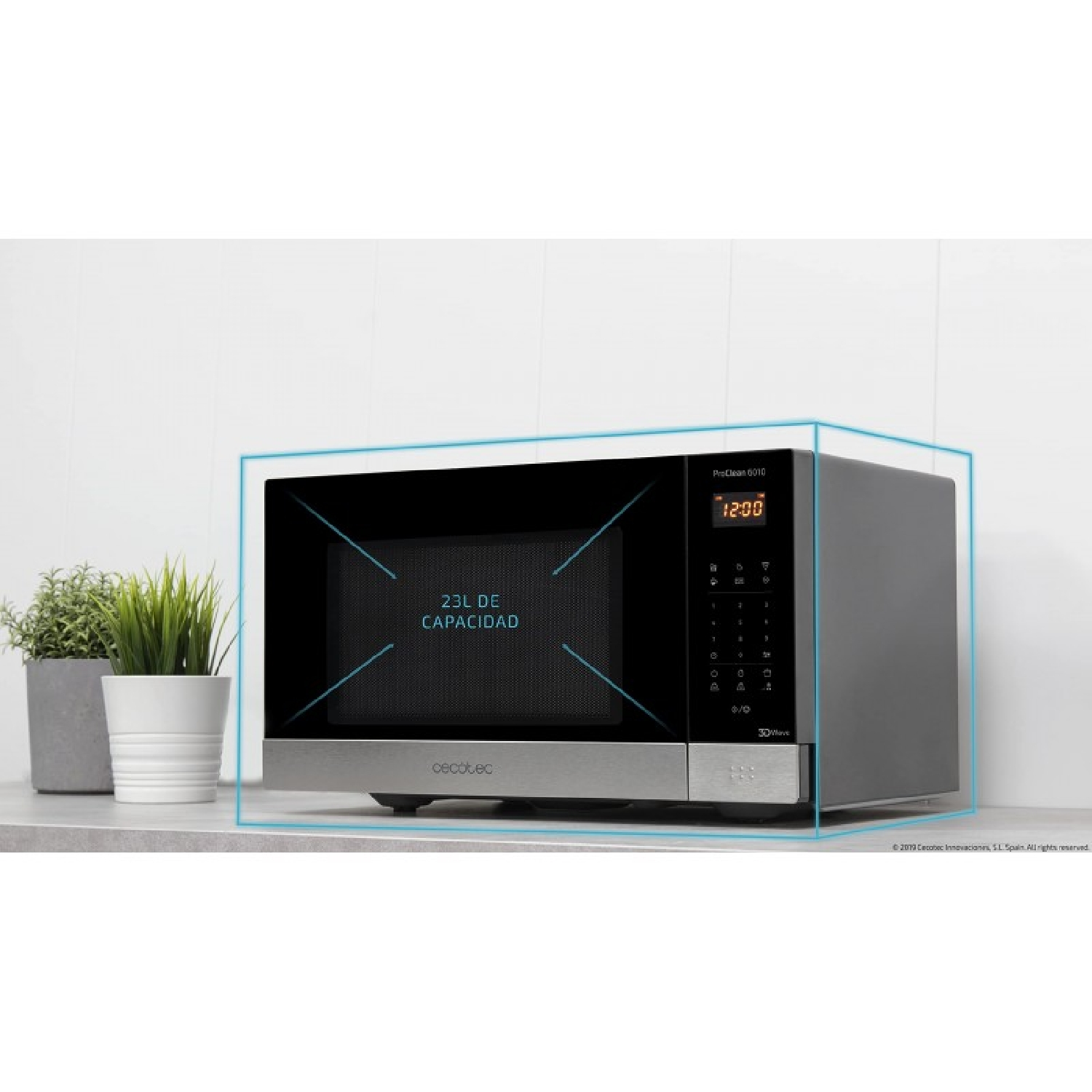 Un forno a microonde con frontale nero e base argentata. Ha un display digitale dell'orologio. Due piante in vaso a sinistra.