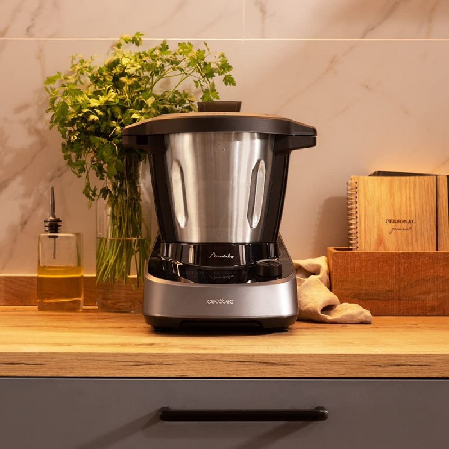 Scena di cucina con robot da cucina su un bancone di legno. Bouquet di prezzemolo, bottiglia d'olio e diario personale.