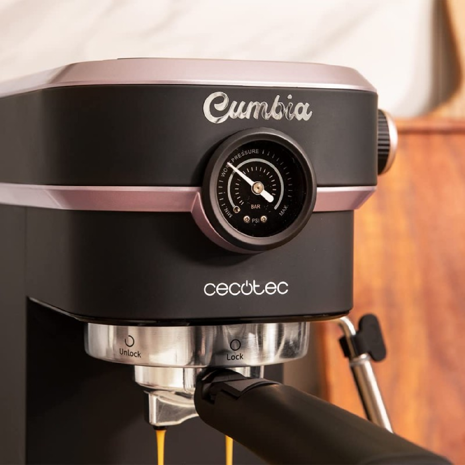 Eine schwarze und roségoldene Cecotec Cumbia Espressomaschine. Sie hat ein Manometer und gibt Kaffee in eine Tasse aus.