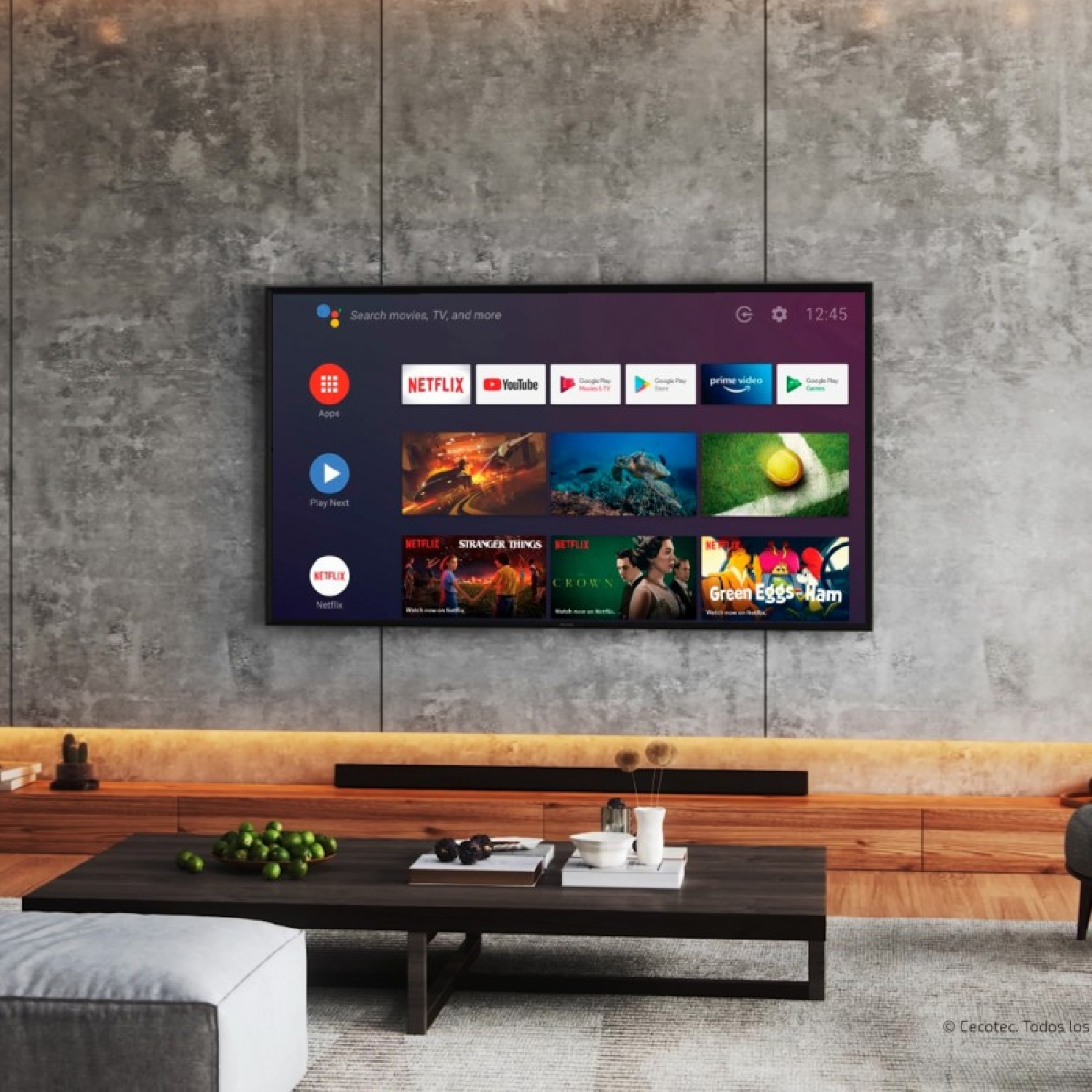 Uno schermo TV mostra app come Netflix e YouTube. Un tavolo di legno con decorazioni davanti a un muro grigio.