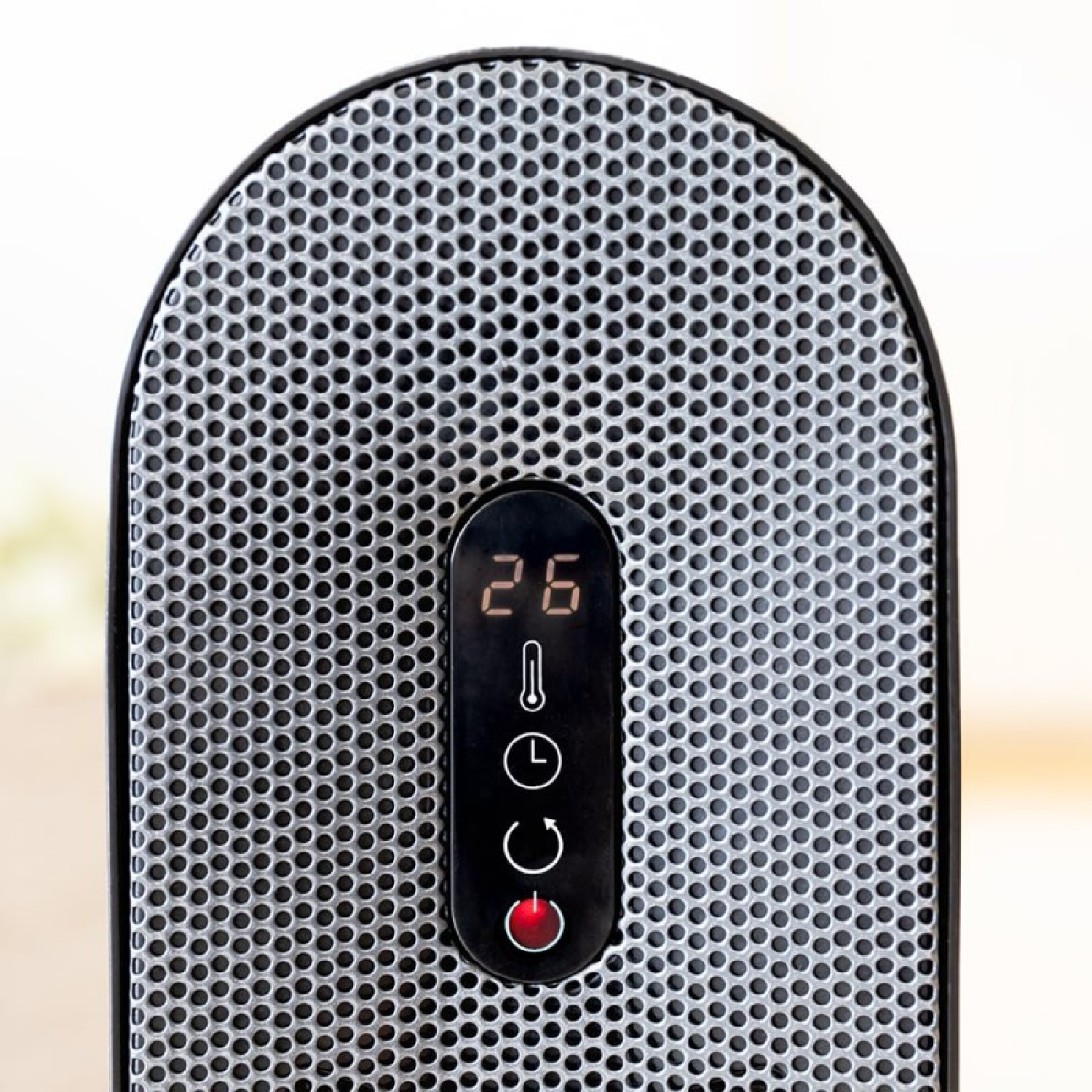 Primer plano de un calentador negro y plateado. Tiene una pantalla digital que muestra 26. Hay ajustes de energía, temporizador y calor.