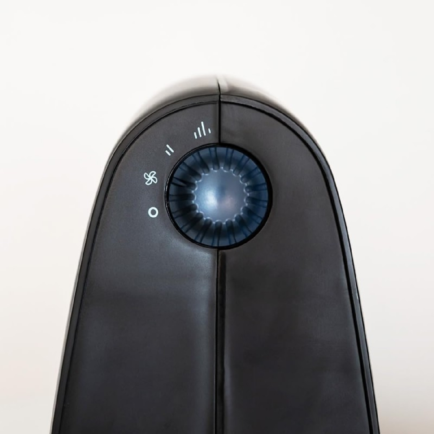 Nahaufnahme eines schwarzen Ventilators. Ein blau beleuchtetes Zifferblatt befindet sich in der Mitte. Symbole für die Lüftergeschwindigkeit sind sichtbar. Weißer Hintergrund.