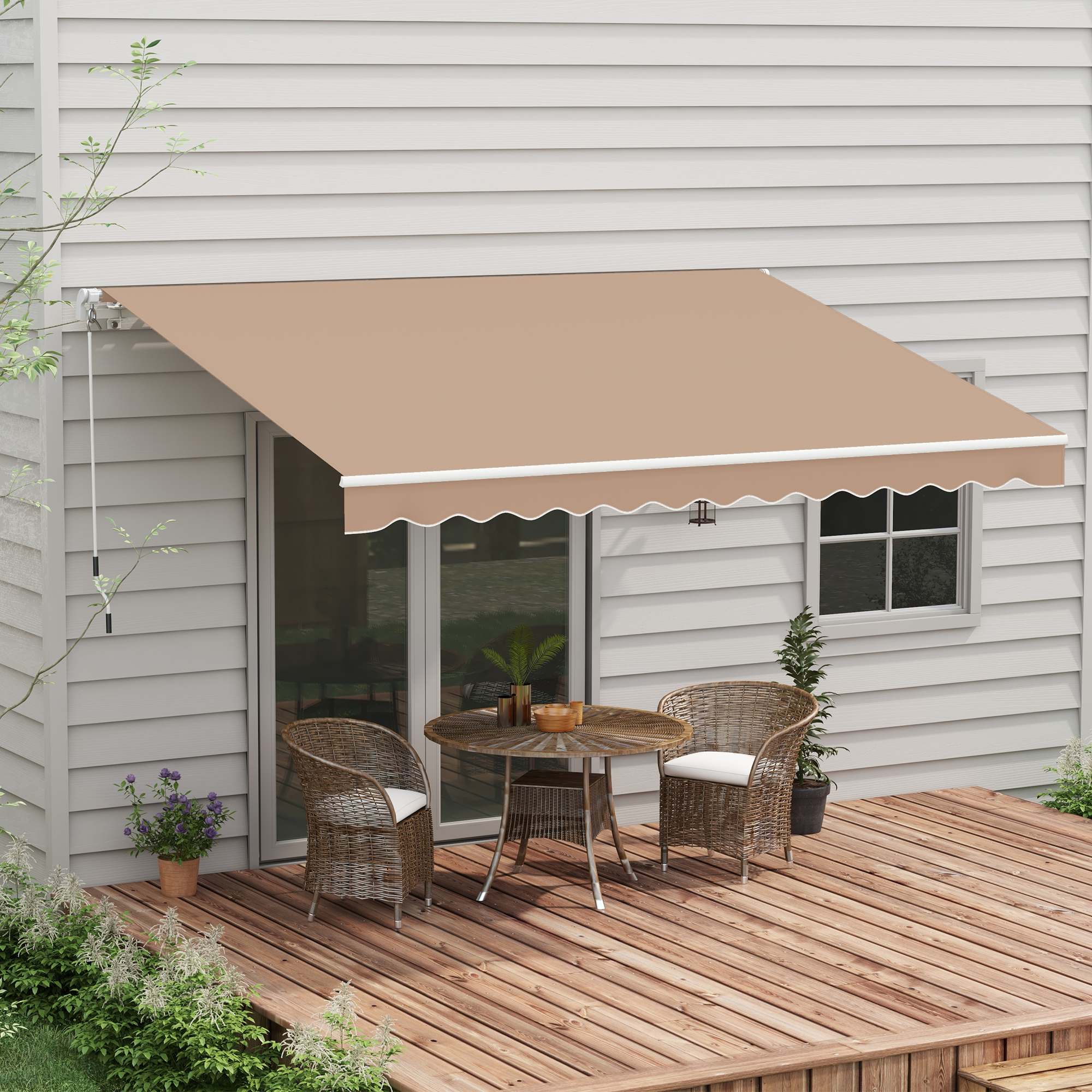 Una tenda da sole beige sopra un patio con tavolo e sedie. Piante e una casa sullo sfondo.