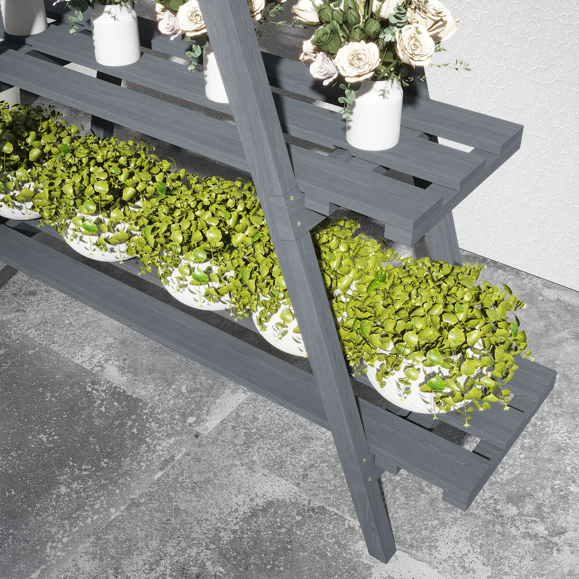 Soporte de planta gris de madera con macetas blancas de plantas verdes y jarrones blancos con flores. Piso de concreto gris.