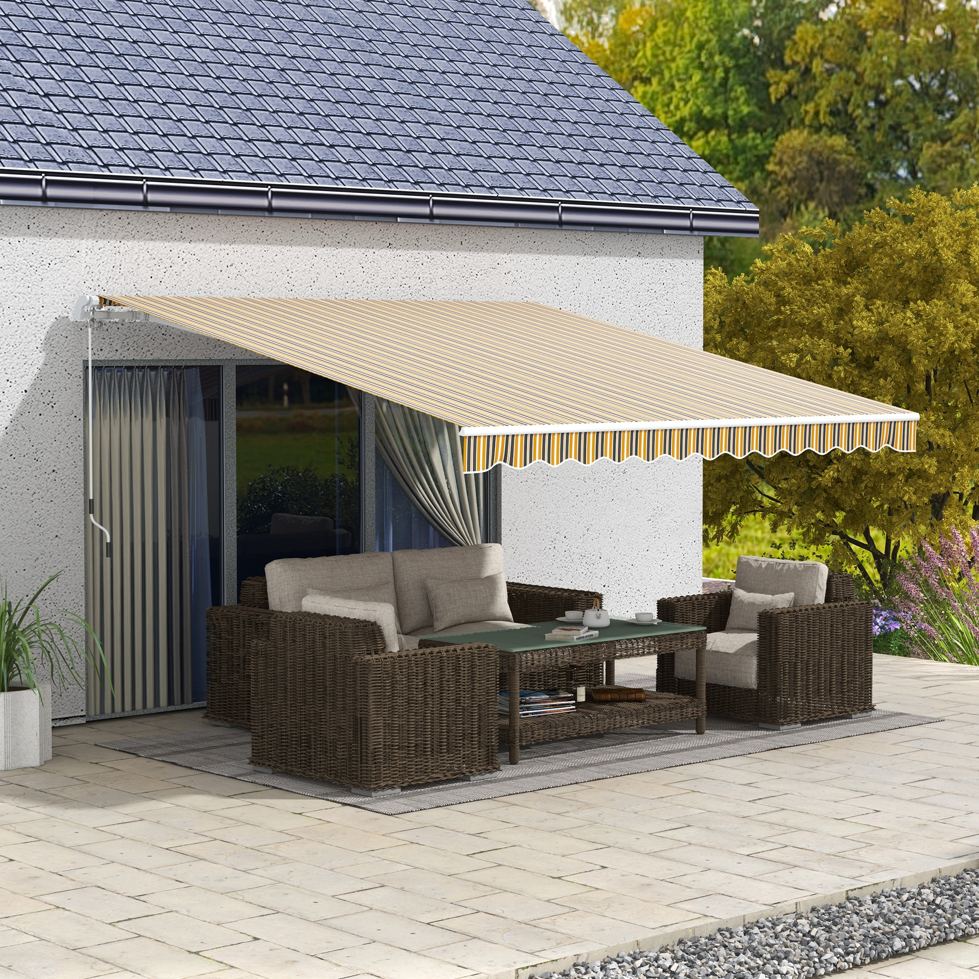 Un toldo a rayas beige se extiende sobre un patio con muebles de mimbre. Una casa con techo oscuro es el telón de fondo.