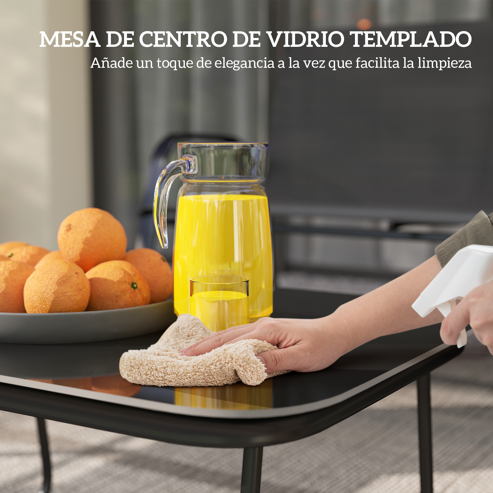 Una persona limpia una mesa negra con un pulverizador y un paño. Naranjas, zumo y un vaso están sobre la mesa.