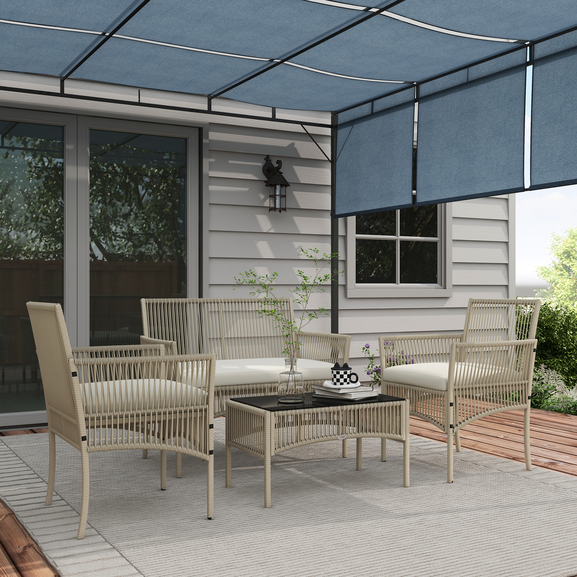 Escena de patio con muebles beige, toldo azul y mesa de cristal. El fondo muestra una casa blanca y vegetación.