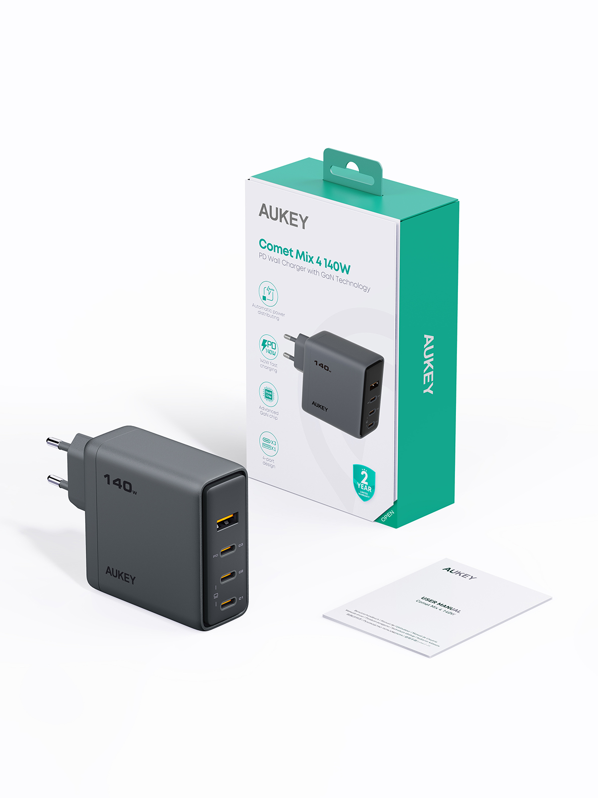 Un cargador AUKEY Comet Mix 4 140W, caja y manual. El cargador es gris oscuro con cuatro puertos. La caja es verde y blanca.