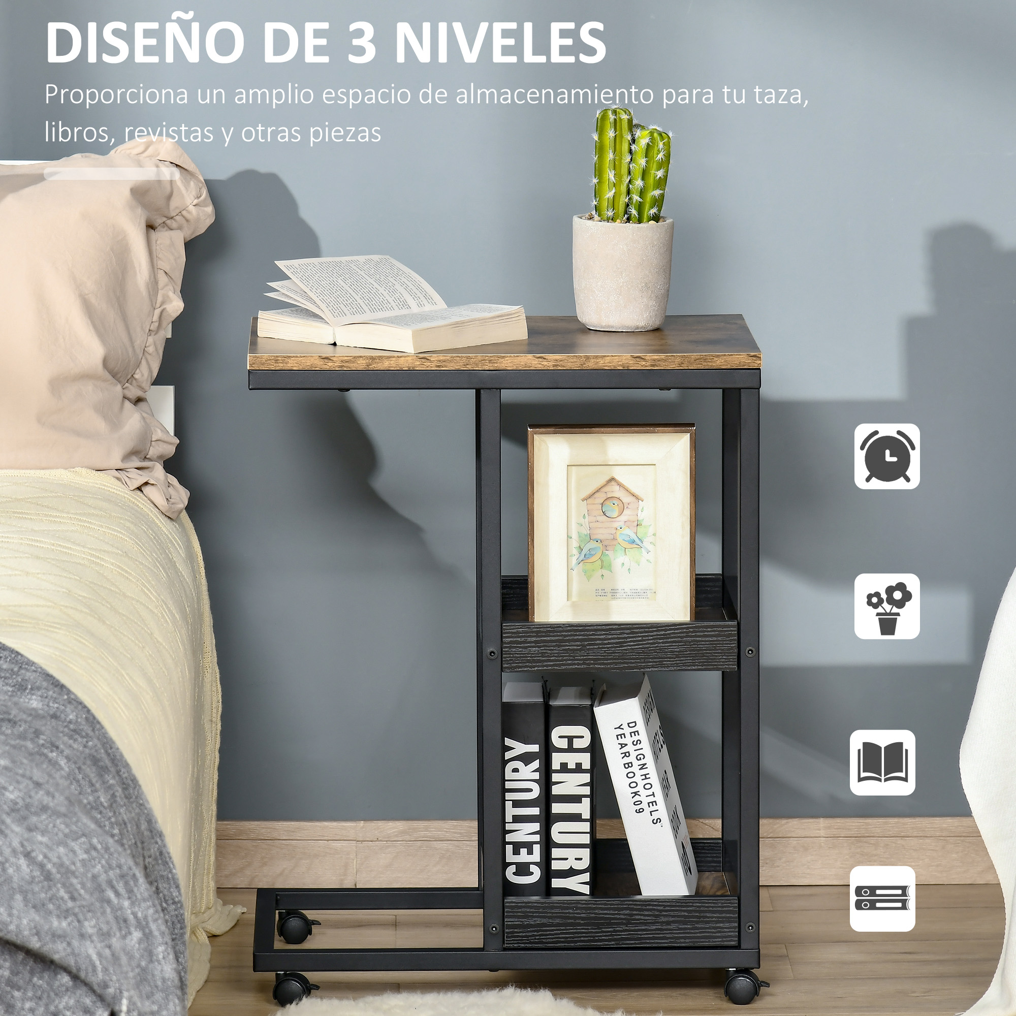 Una mesa auxiliar de tres niveles con un cactus, libros y un marco de fotos. La ropa de cama es visible en el fondo.