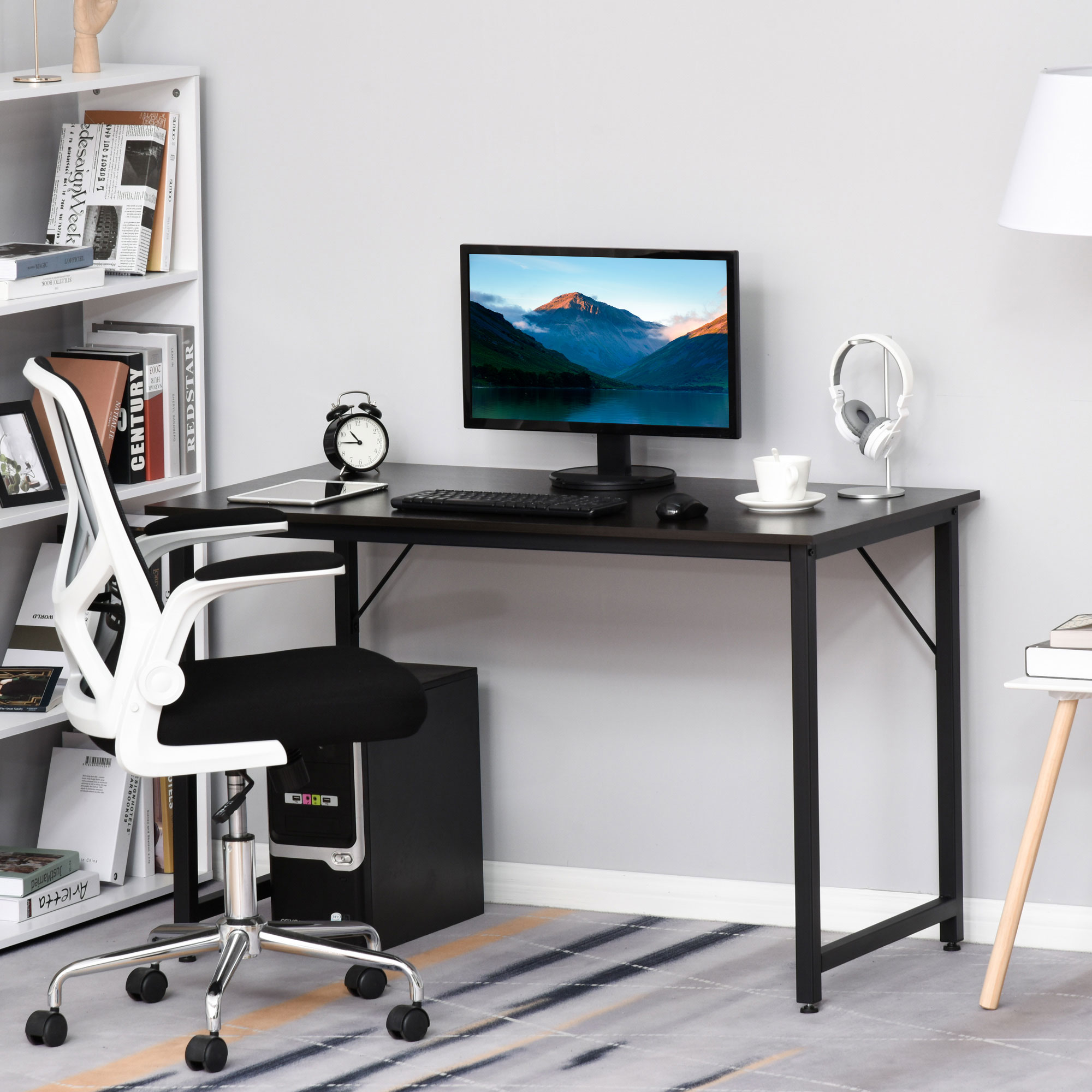 Escritorio con computadora, silla y accesorios. Estantería y lámpara a los lados. Combinación de colores blanco y negro.