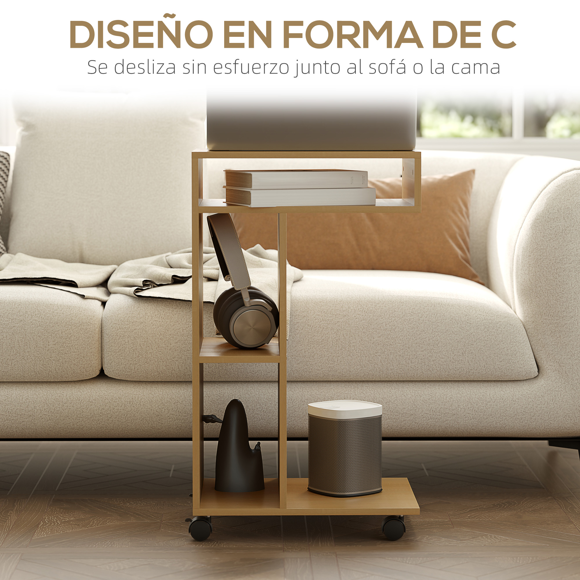 Una mesa auxiliar en forma de C con un portátil, libros, auriculares y altavoz. Tiene ruedas y está junto a un sofá.