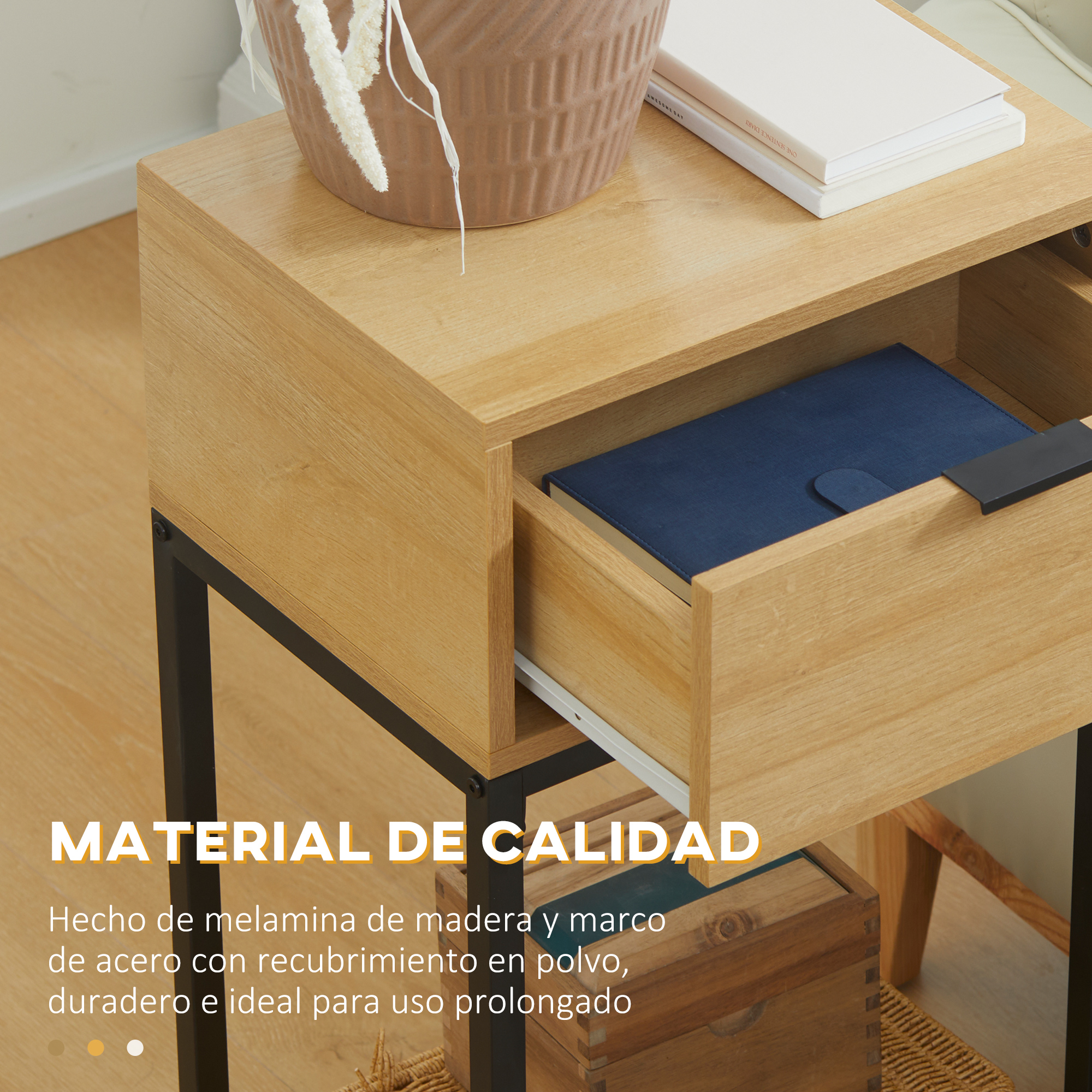 Mesita de noche de madera con cajón abierto, un libro y una planta. Marco de metal negro. El cajón tiene un cuaderno azul.