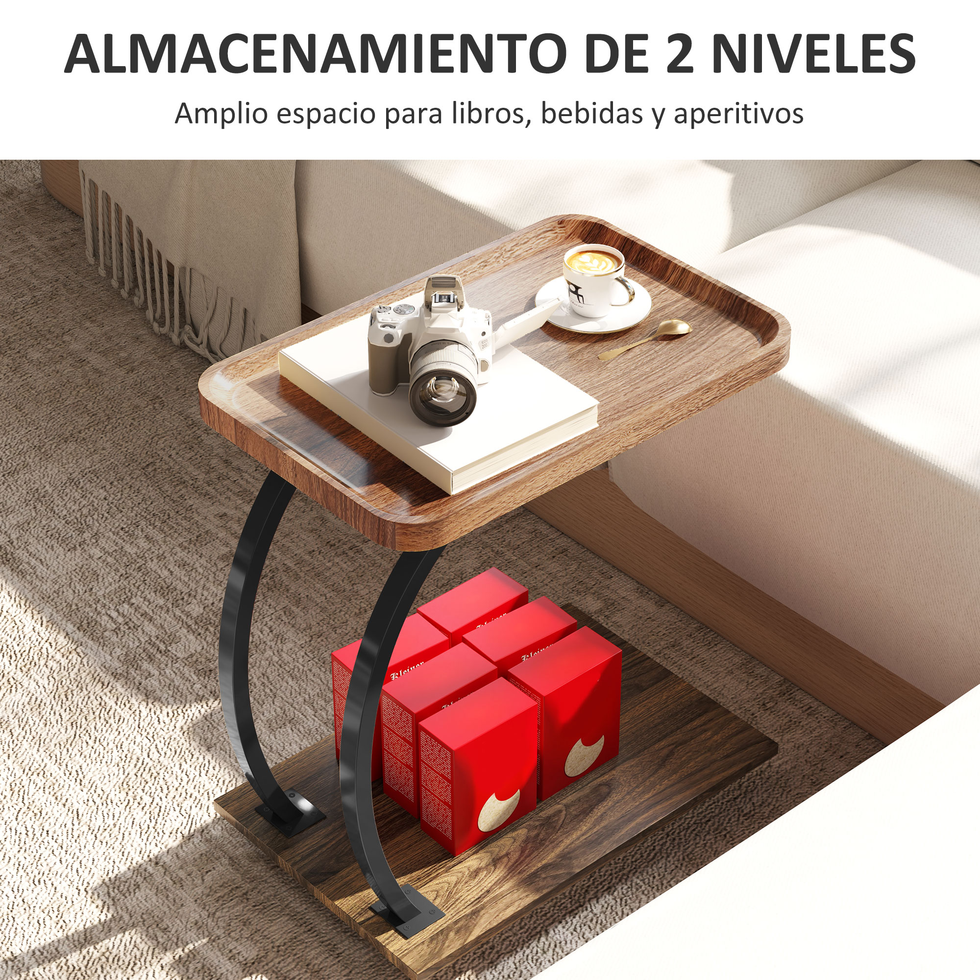 Una mesa auxiliar de madera de dos niveles con cámara, taza de café y cajas rojas. Un sofá beige al fondo.