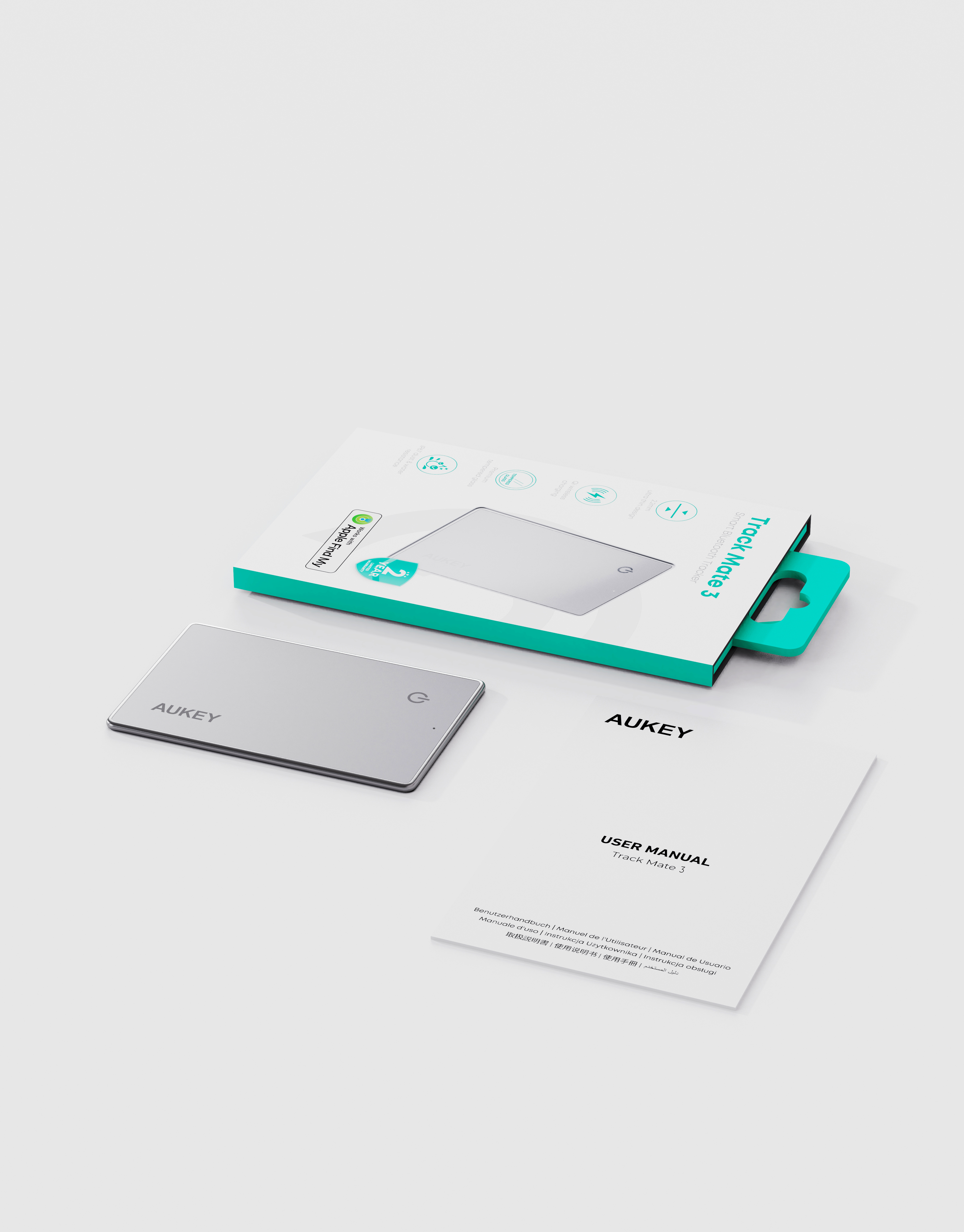 Toma del producto con un AUKEY Track Mate 3 plateado, caja y manual de usuario sobre una superficie blanca.