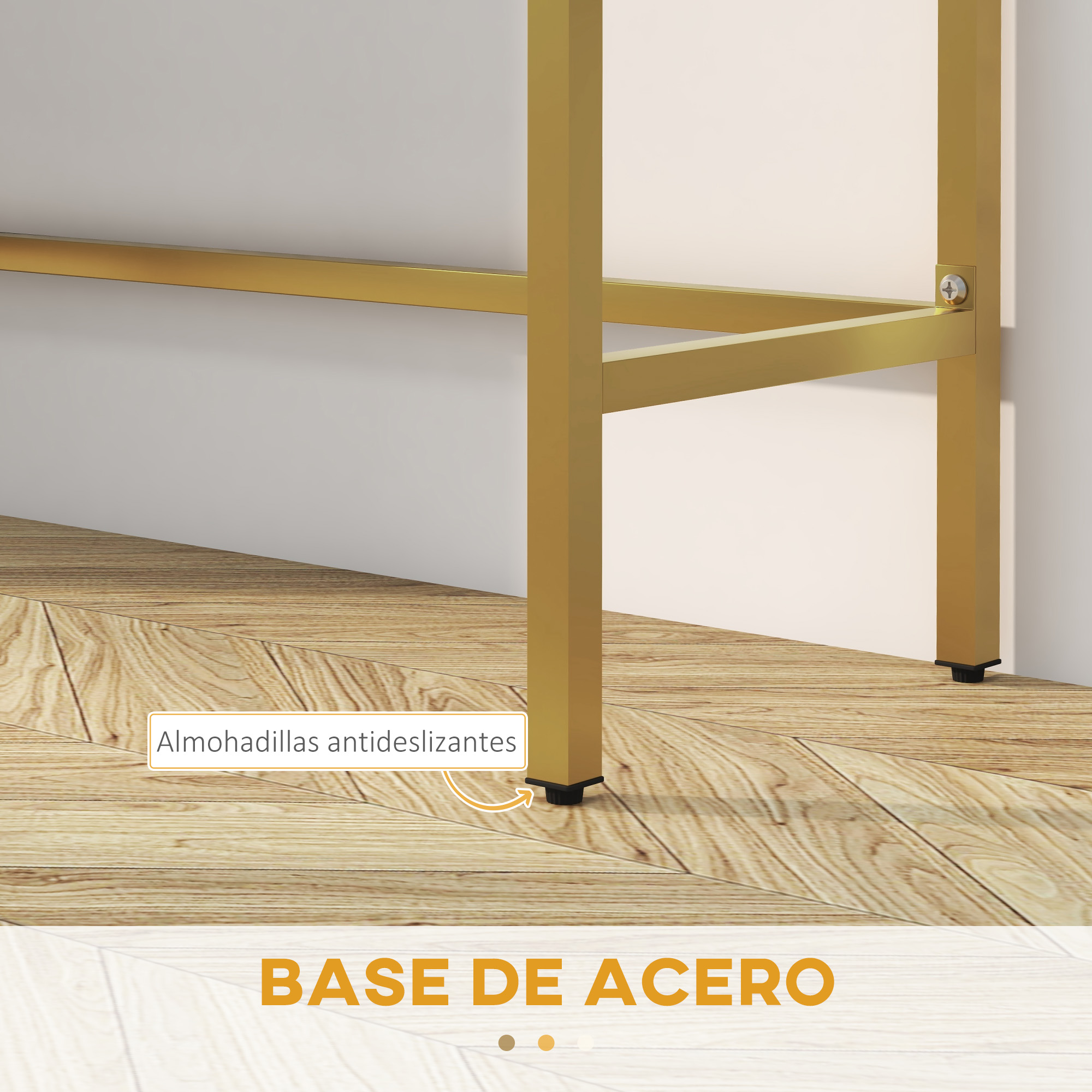 Pata de mesa de acero dorado con almohadillas antideslizantes negras sobre suelo de madera, contra pared blanca.