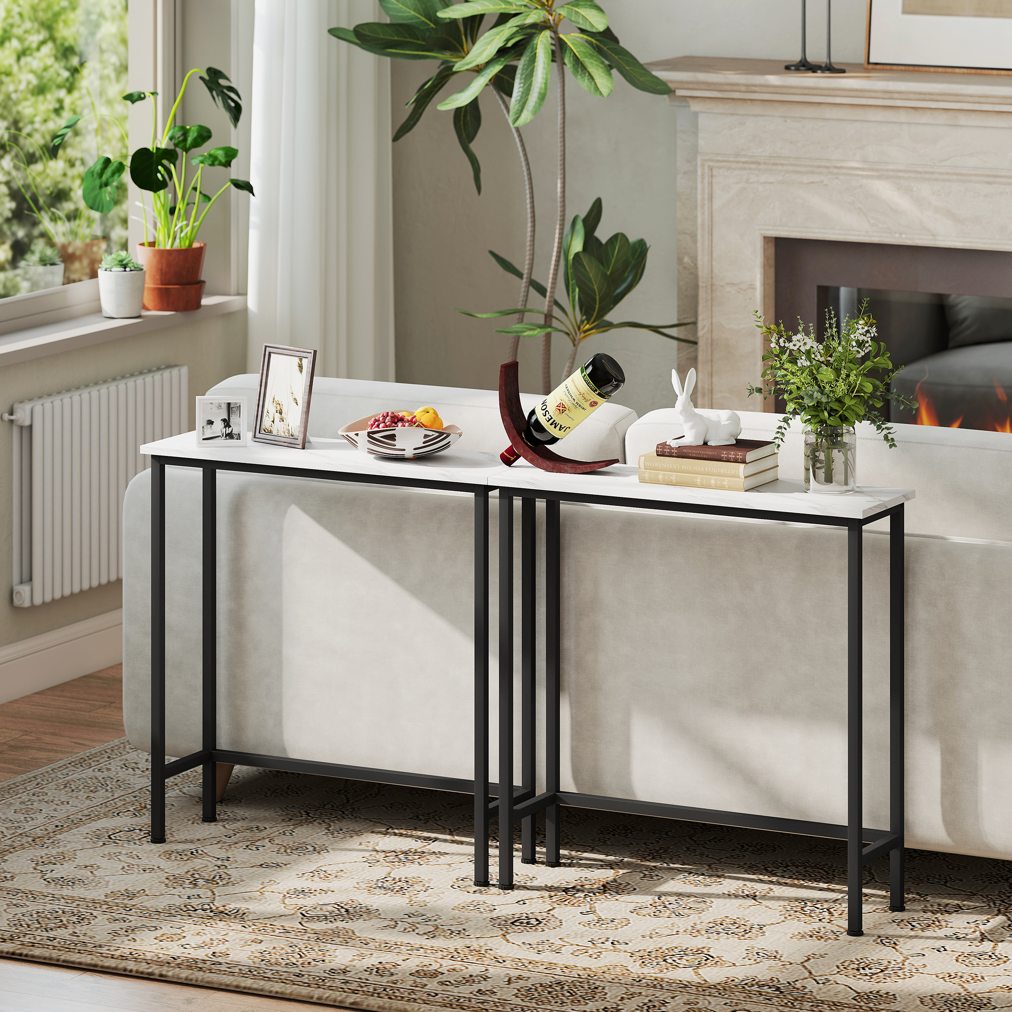 Salón con sofá blanco, mesa con frutas y vino, plantas, chimenea y alfombra estampada.