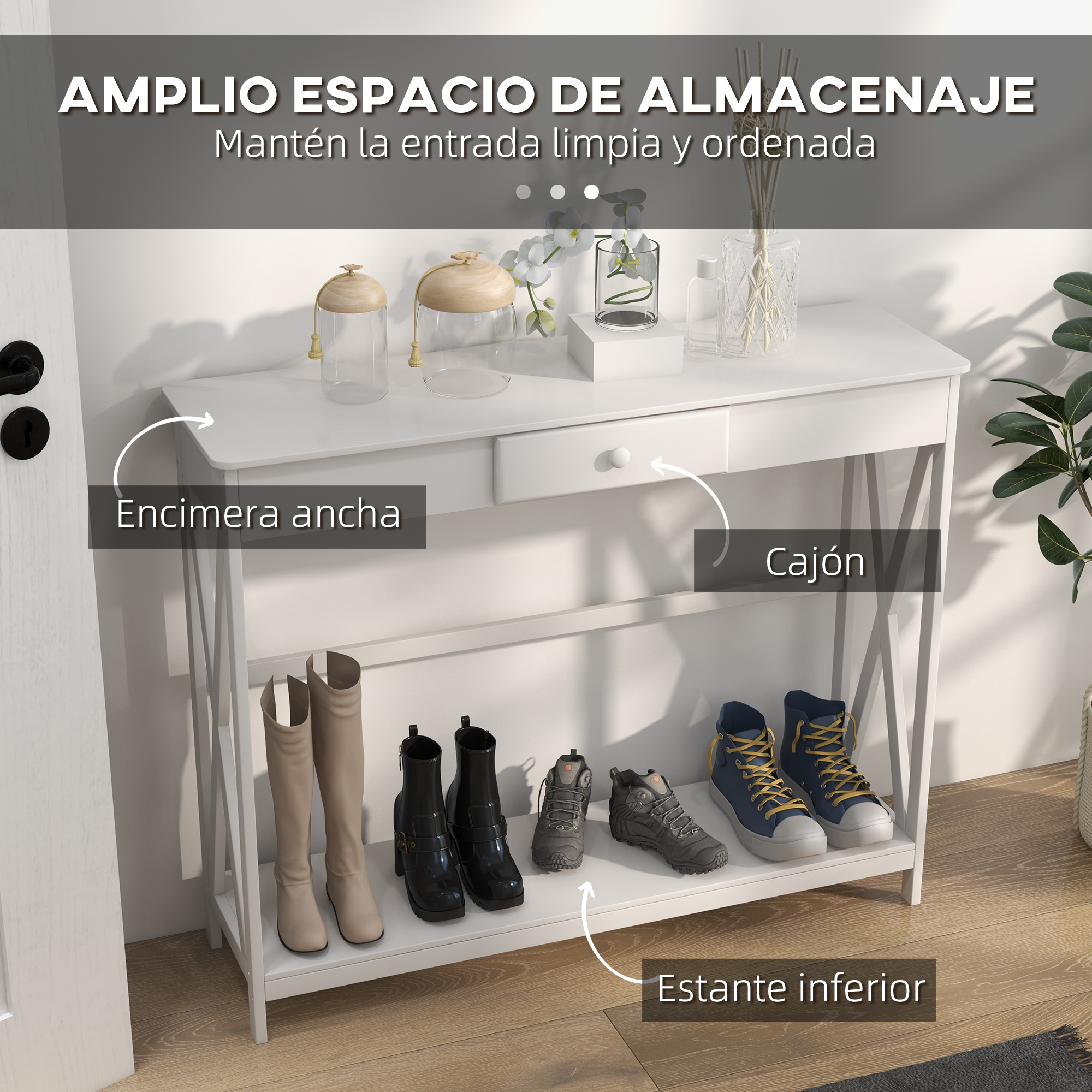 Una mesa de entrada blanca con un cajón. Botas y zapatos en el estante inferior. Objetos decorativos arriba.