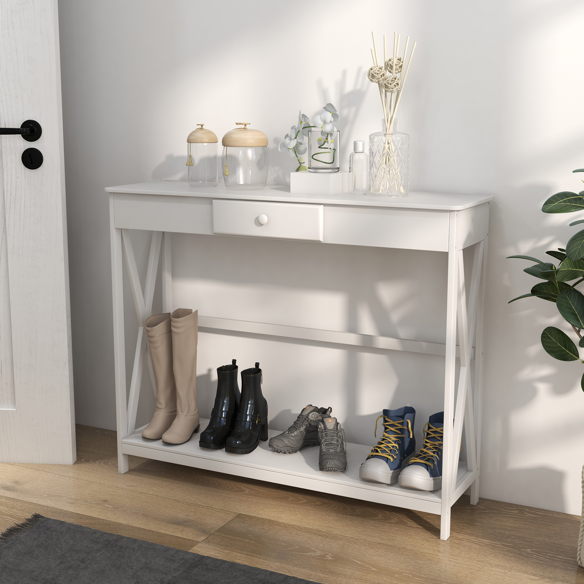 Mesa de entrada blanca con botas y zapatos. Objetos decorativos encima. Puerta y planta al lado.
