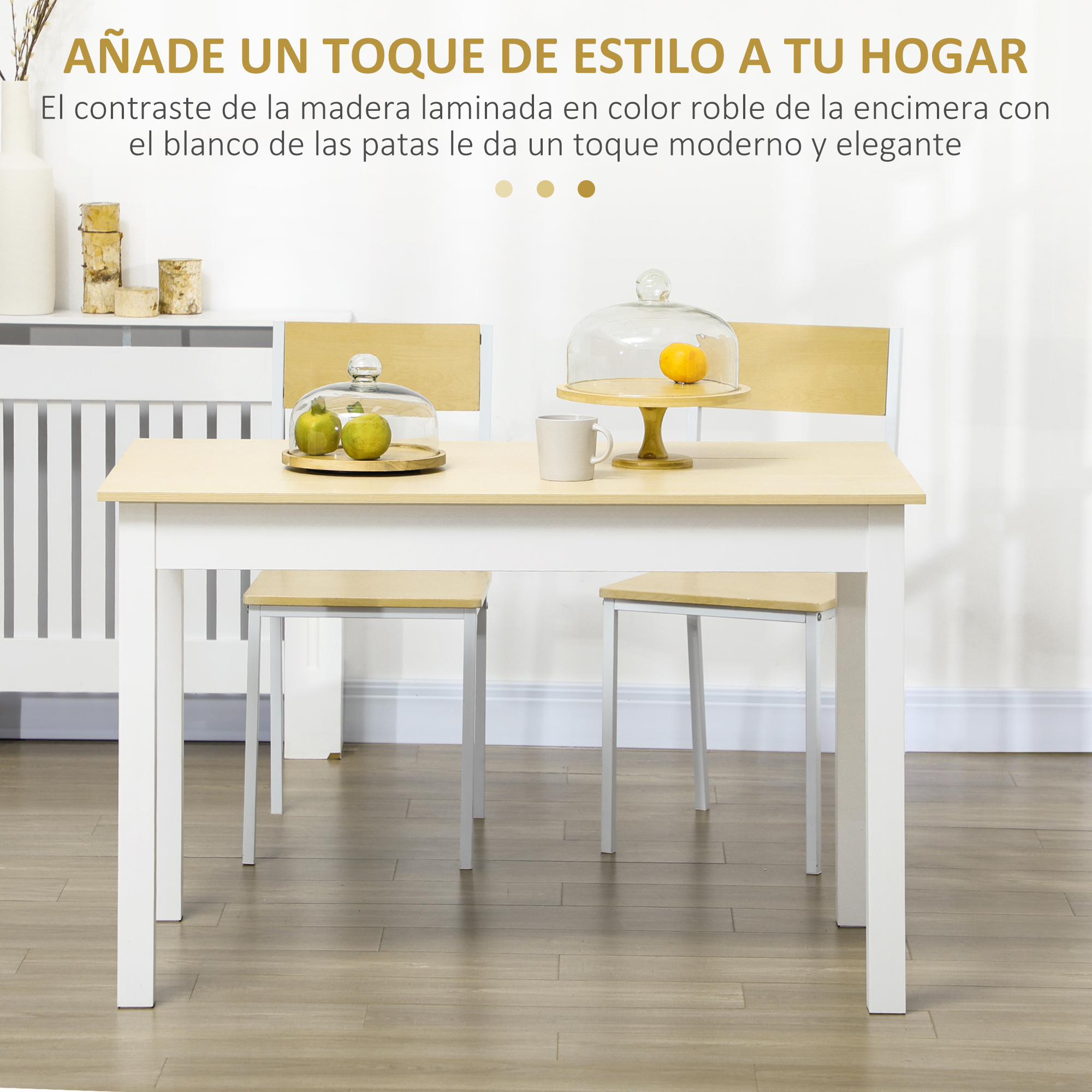 Una mesa de comedor con tapa de madera y patas blancas, con dos sillas. Frutas bajo campanas de cristal.