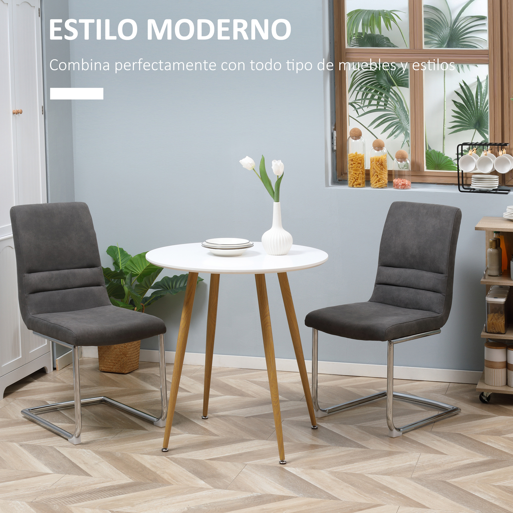 Comedor con mesa, sillas y ventana. La mesa tiene un jarrón con flores. Sillas grises.