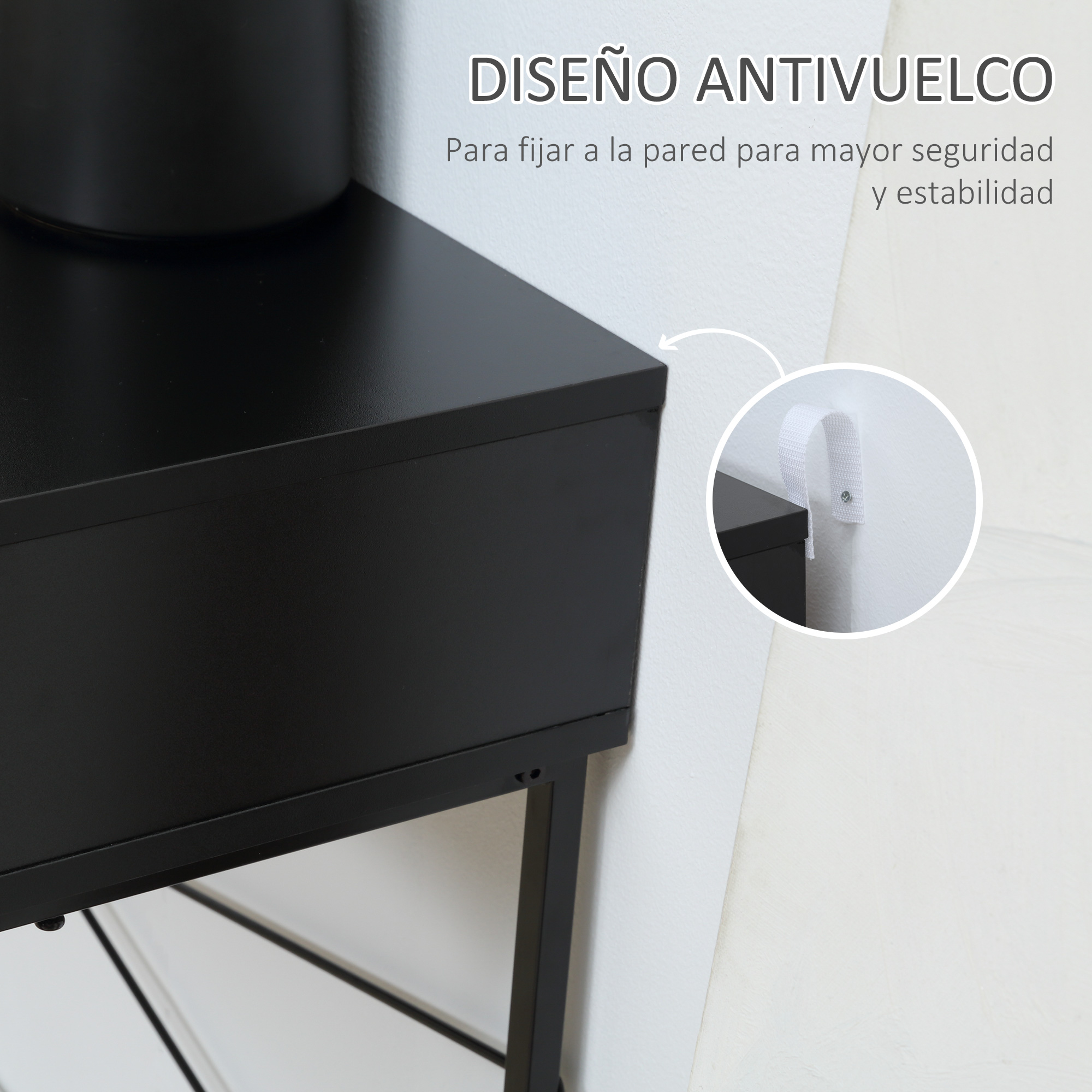 Esquina de mesa negra con fijación a la pared para seguridad. Correa blanca fijada a la pared.