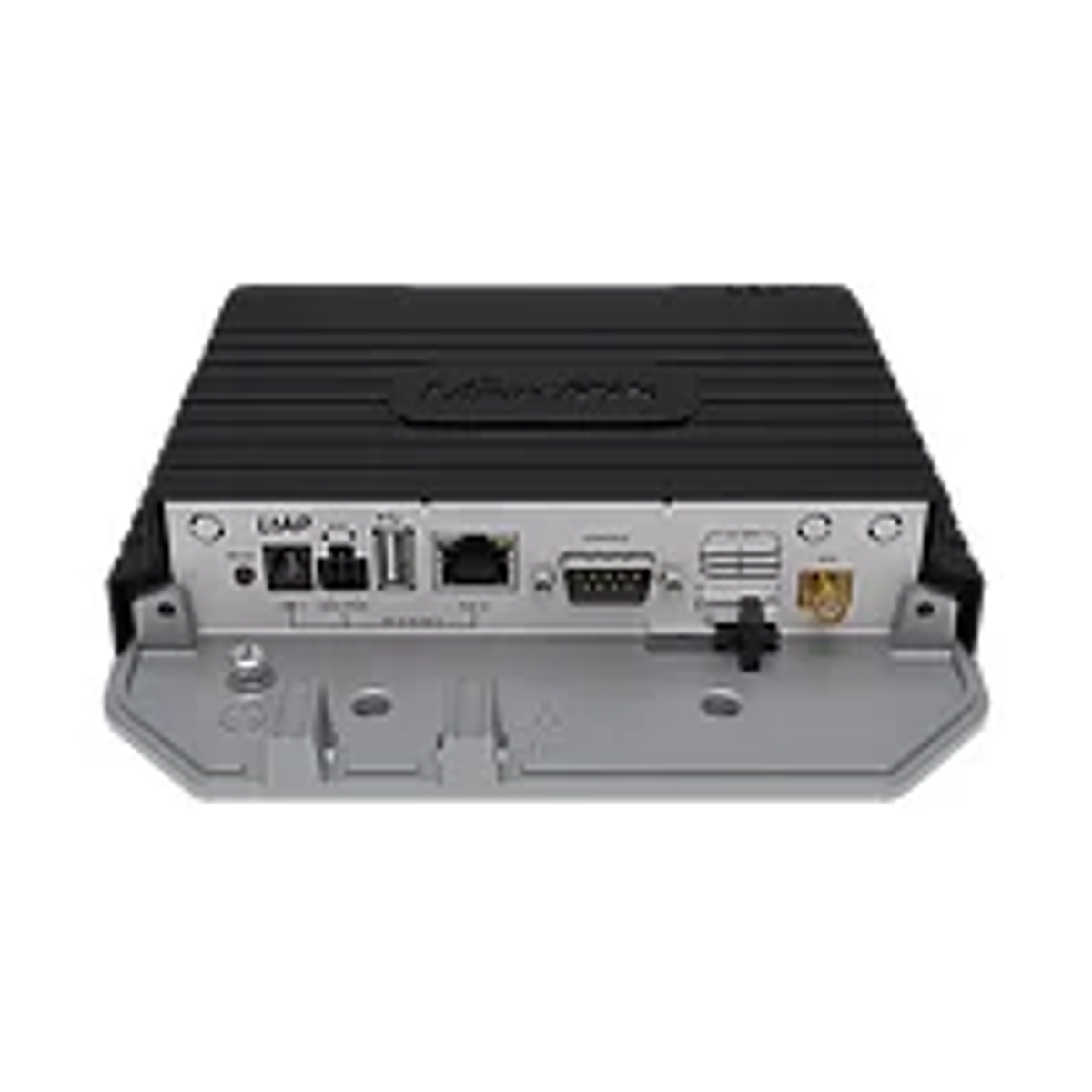 Un dispositivo rectangular negro con varios puertos y conectores. Se apoya sobre una base metálica gris. El dispositivo tiene una parte superior acanalada.