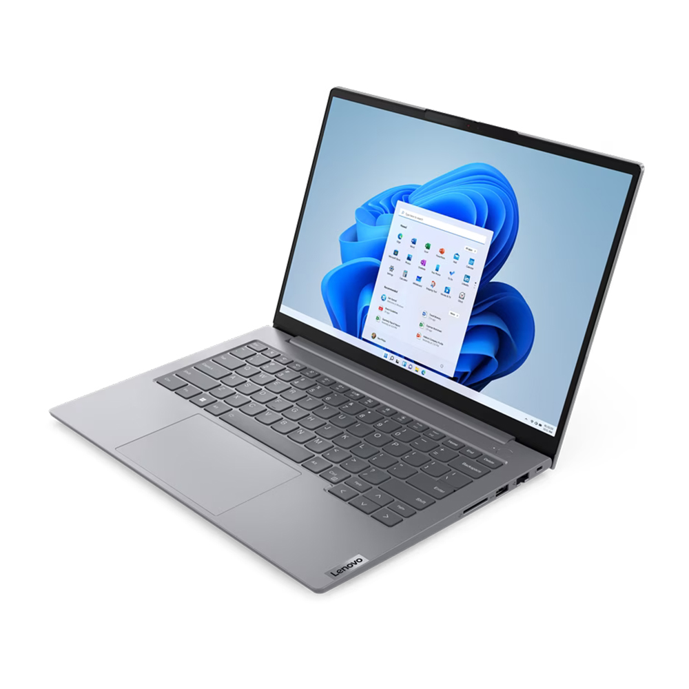 Gri bir Lenovo dizüstü bilgisayar açık, Windows 11 arayüzünü gösteriyor. Ekran mavi bir arka plan ve uygulama simgeleri gösteriyor. Klavye görünür durumda.