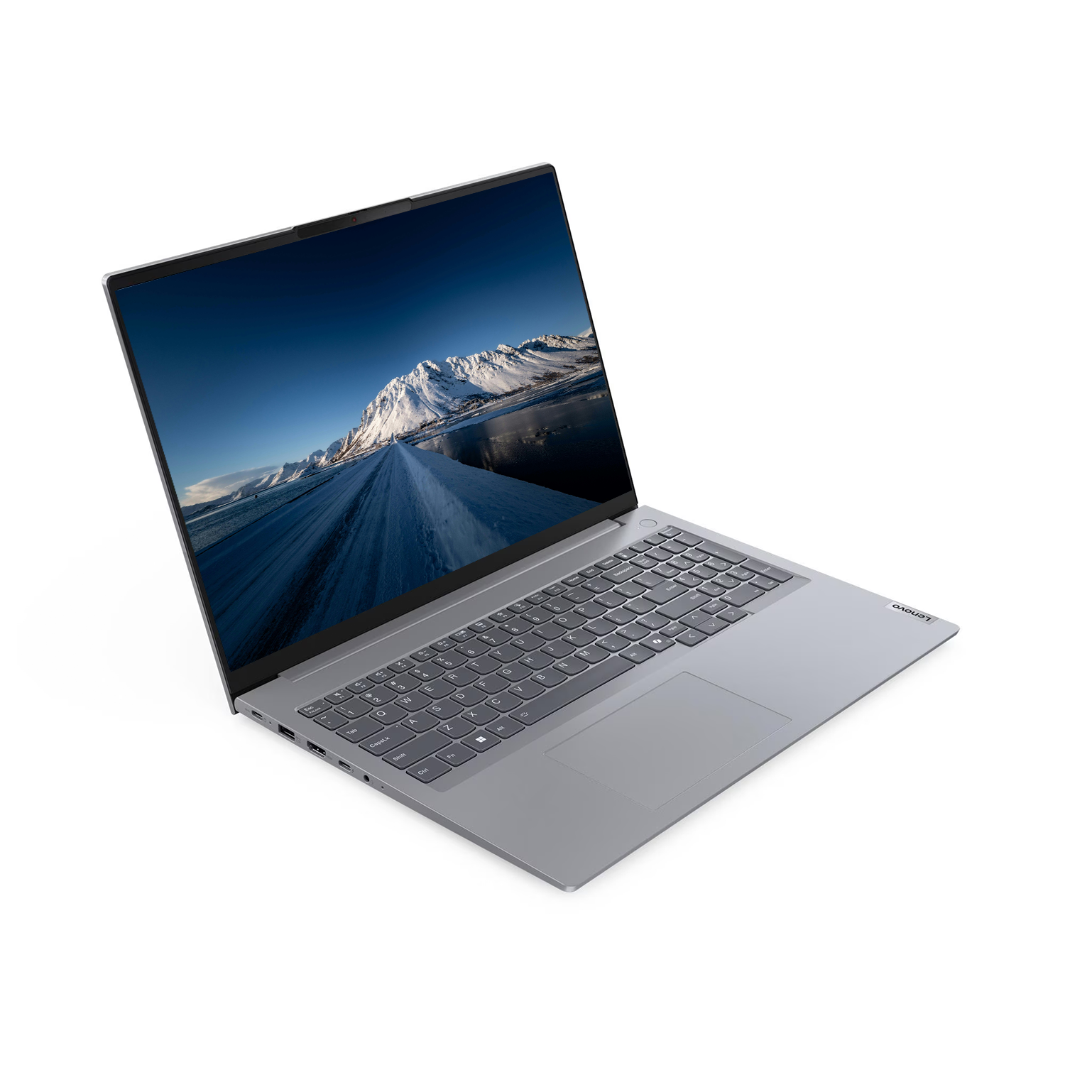 Gri bir Lenovo dizüstü bilgisayar açık, karlı bir yol sahnesi gösteriyor. Beyaz zemin üzerinde klavye ve dokunmatik yüzey görünür.