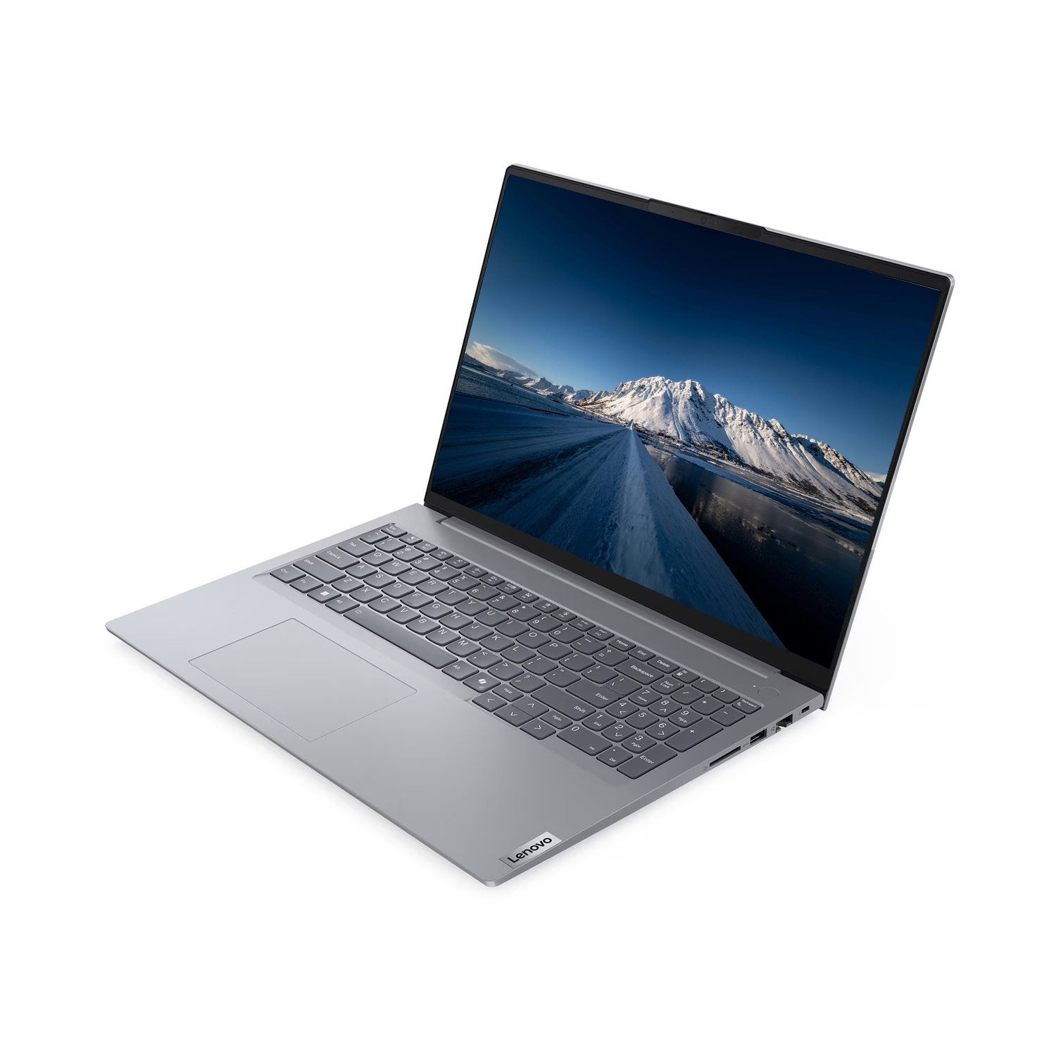 Gümüş renkli bir Lenovo dizüstü bilgisayar açılı olarak gösteriliyor. Ekran, karlı bir dağ manzarasını gösteriyor. Klavyesi görünür durumda.