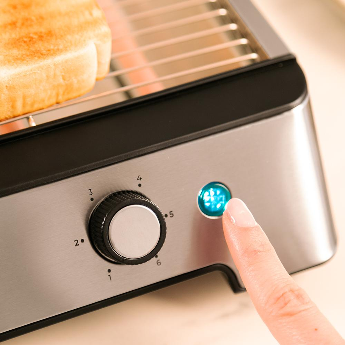 Una mano presiona el botón azul de una tostadora. Una rebanada de pan tostado está en la tostadora. Un dial está configurado en el número 3.
