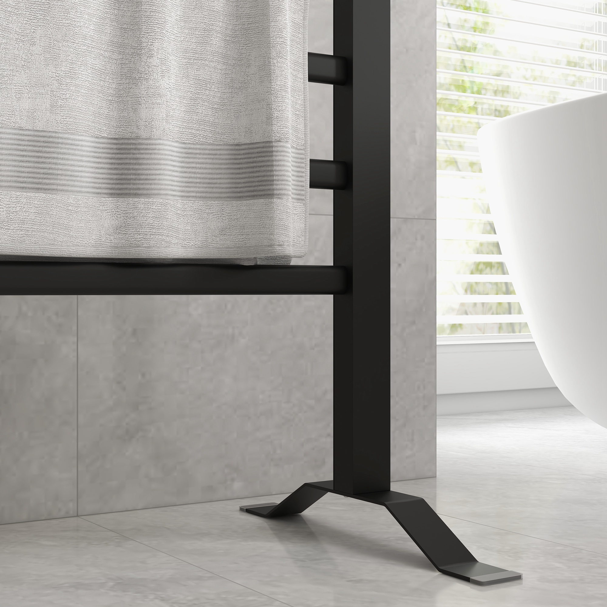 Una scena di bagno moderna con un portasciugamani nero che tiene un asciugamano bianco. Una vasca da bagno bianca è visibile sullo sfondo.