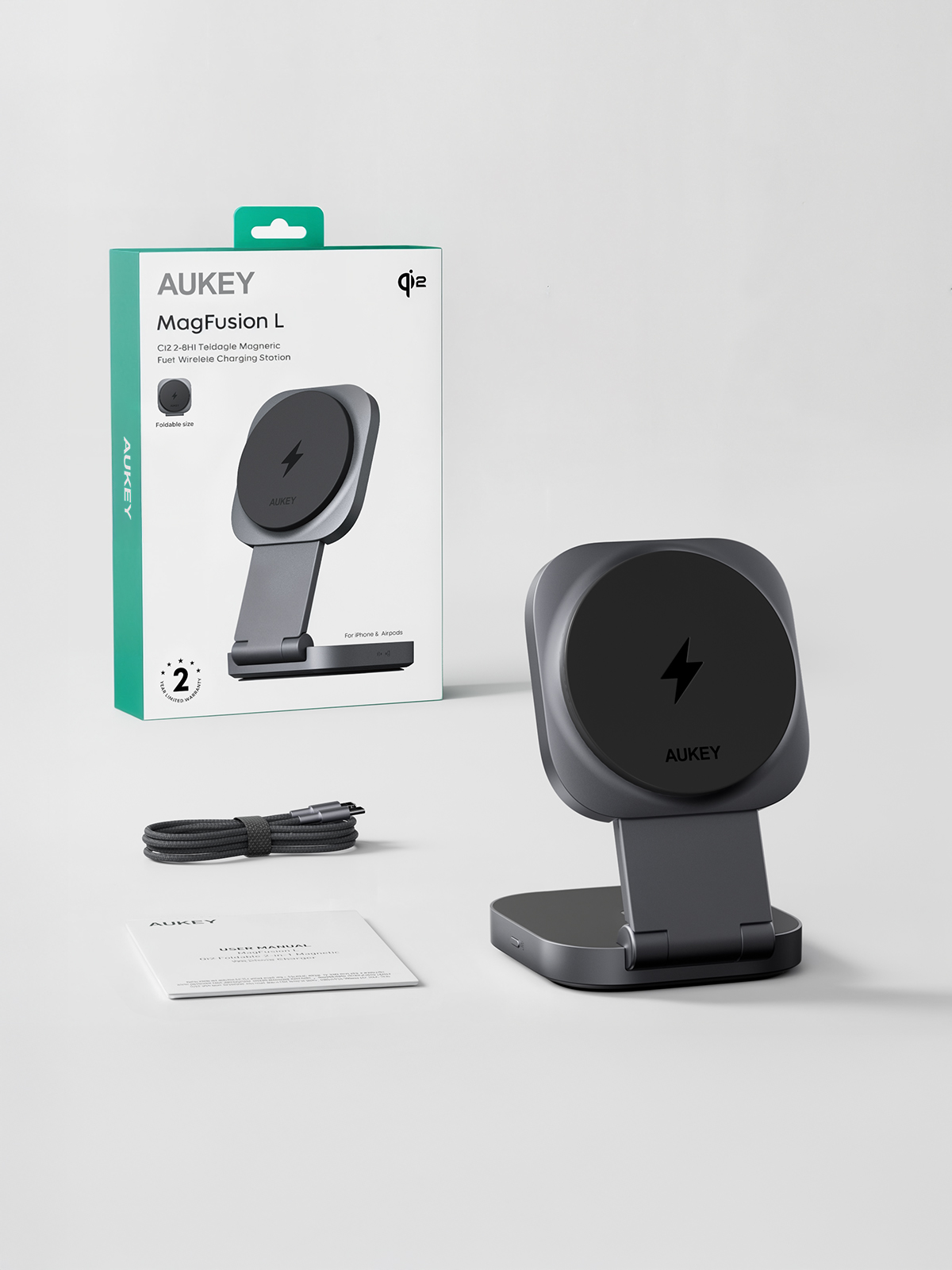 Un cargador inalámbrico gris AUKEY MagFusion L. Tiene una plataforma de carga, un soporte, un cable, un manual de usuario y una caja.