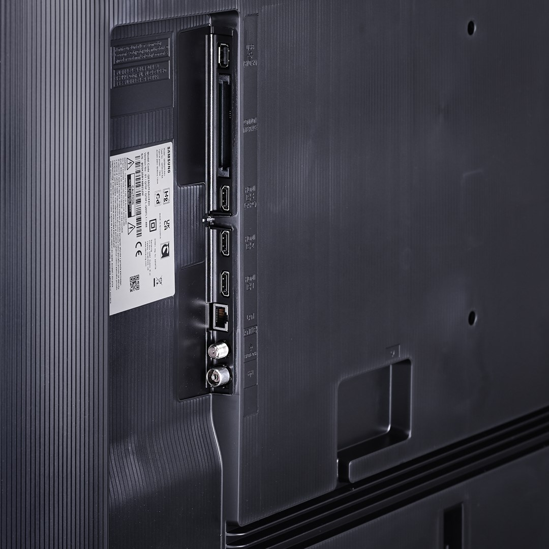 Zbliżenie tyłu czarnego telewizora Samsung. Widoczne porty, etykiety i złącze zasilania.