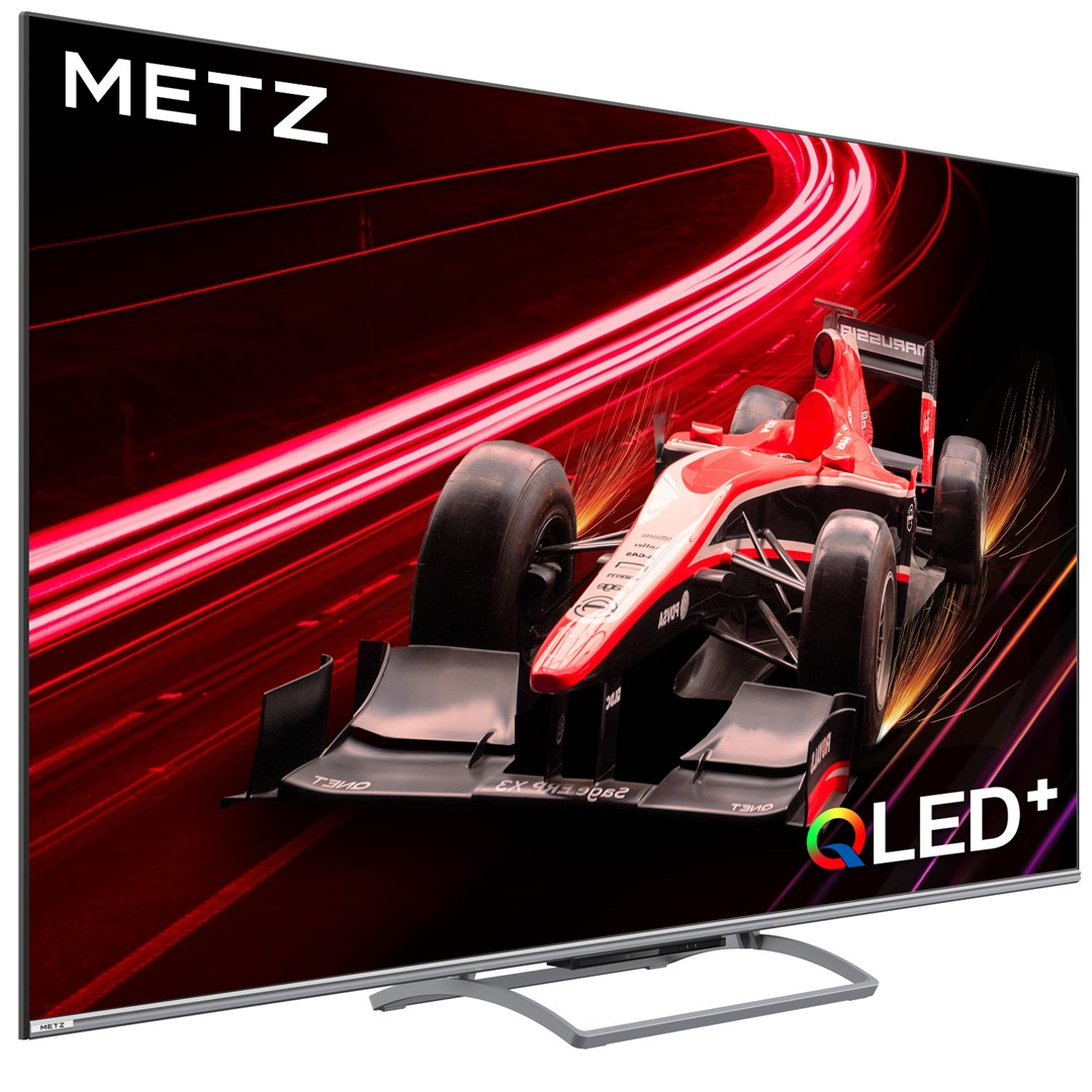 Telewizor Metz OLED+ wyświetla czerwony samochód wyścigowy na czerwono-czarnym abstrakcyjnym tle. Telewizor stoi na srebrnym stojaku.
