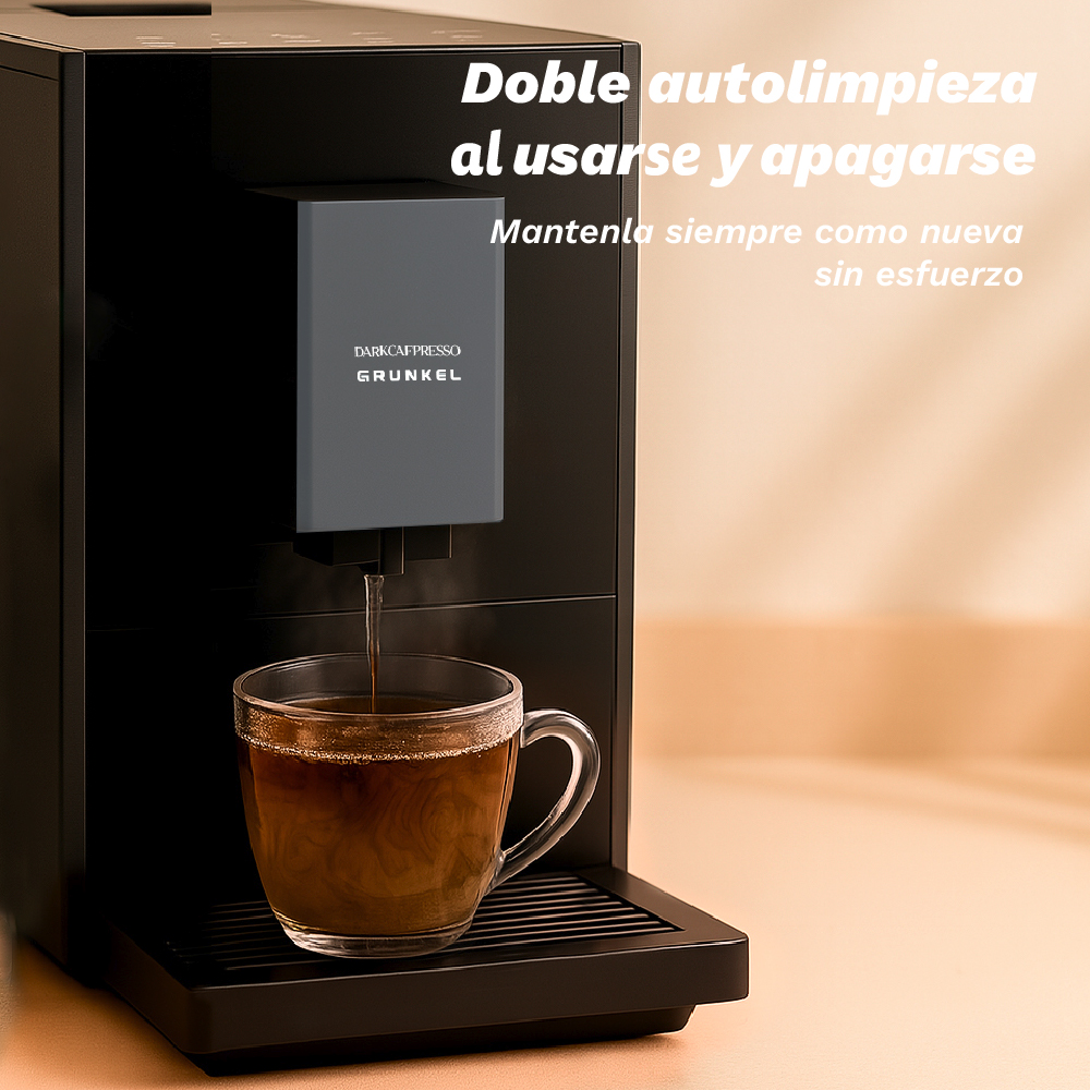 Una máquina de café dispensa café en una taza de vidrio. La máquina es negra con un panel gris. Texto en español.