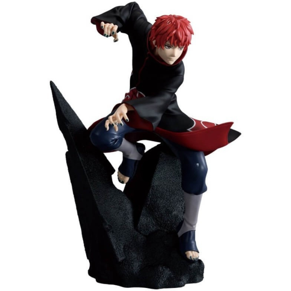 Una statuetta di un personaggio con capelli rossi, mantello nero e pantaloni blu, in posa su una formazione rocciosa nera, in posa d'azione.