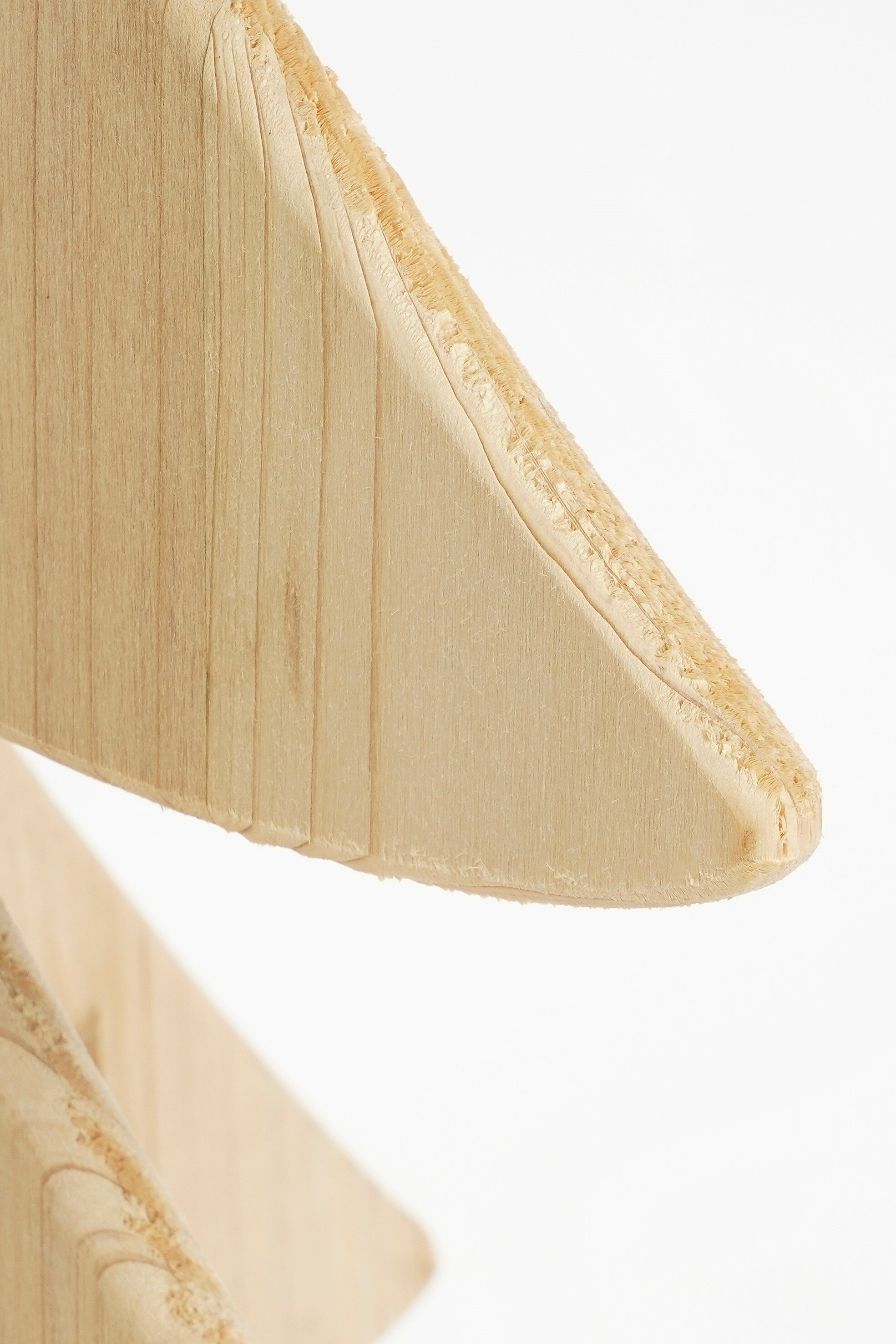 Gros plan d'un objet en bois de couleur brun clair sur fond blanc.
