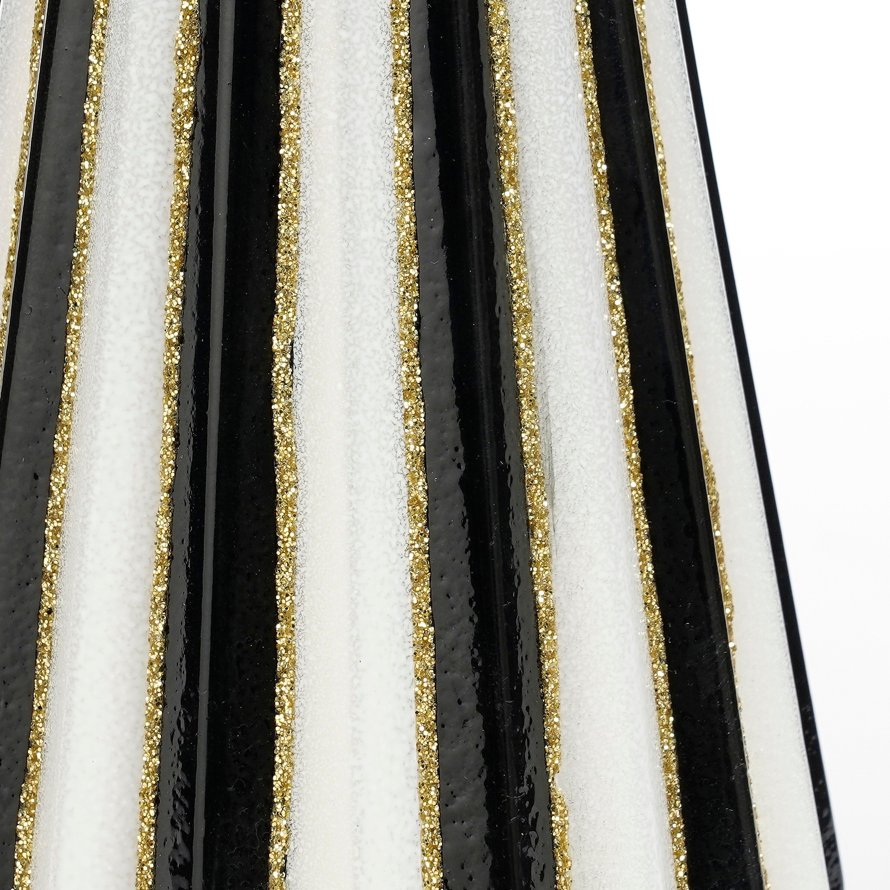 Gros plan d'une surface rayée avec des rayures noires, blanches et dorées pailletées. Le motif est vertical.