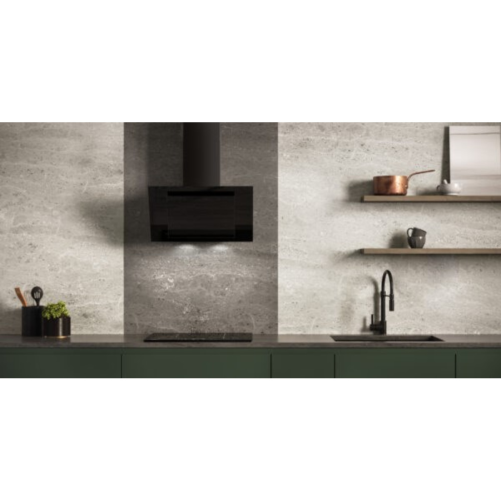 Nowoczesna kuchnia z czarnymi urządzeniami, zielonym blatem i szarą kamienną ścianą. Półki z miedzianym garnkiem i filiżanką.