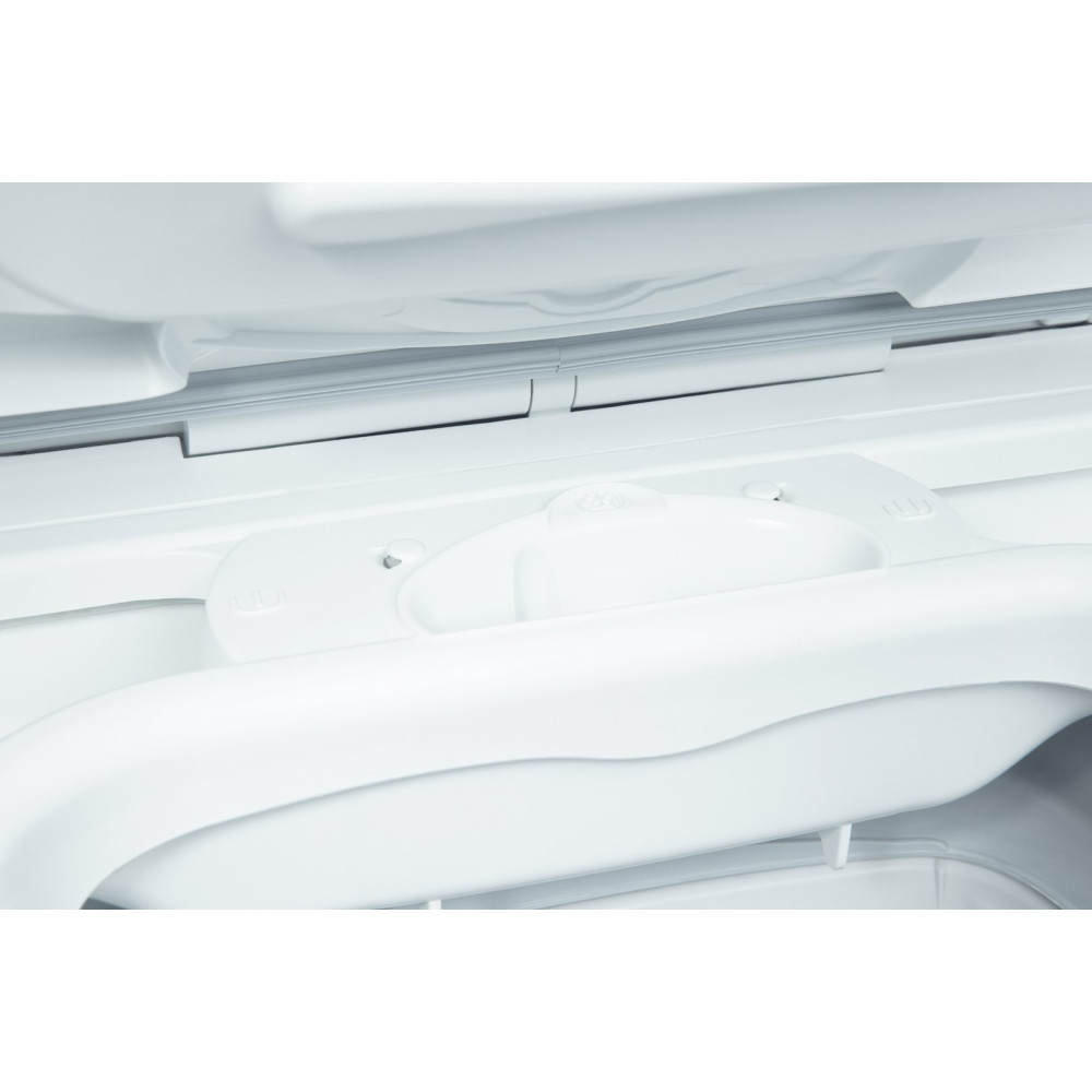 Zbliżenie białego plastikowego wnętrza urządzenia. Widoczny zakrzywiony uchwyt, zatrzask i różne elementy. Wszystkie elementy są białe.