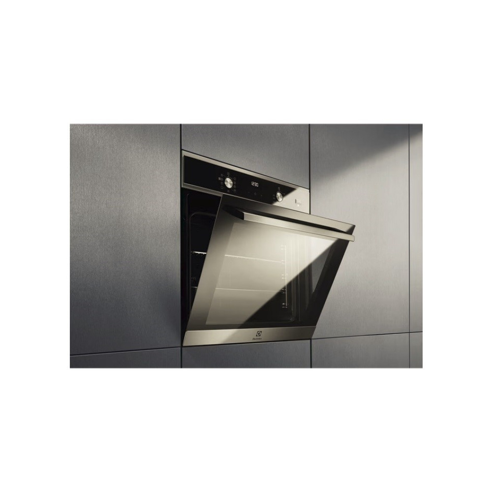 Nowoczesny piekarnik jest wbudowany w ścianę. Drzwi piekarnika są otwarte, a wnętrze widoczne. Piekarnik ma eleganckie, metaliczne wykończenie.