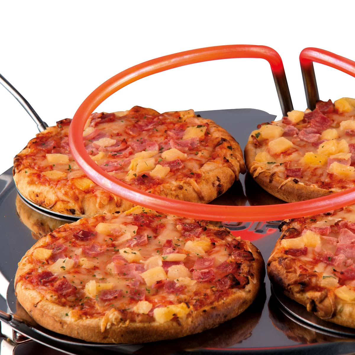 Vier Pizzen mit Ananas und Schinken auf einem silbernen Tablett, umgeben von einem orangefarbenen Heizelement. Der Hintergrund ist weiß.