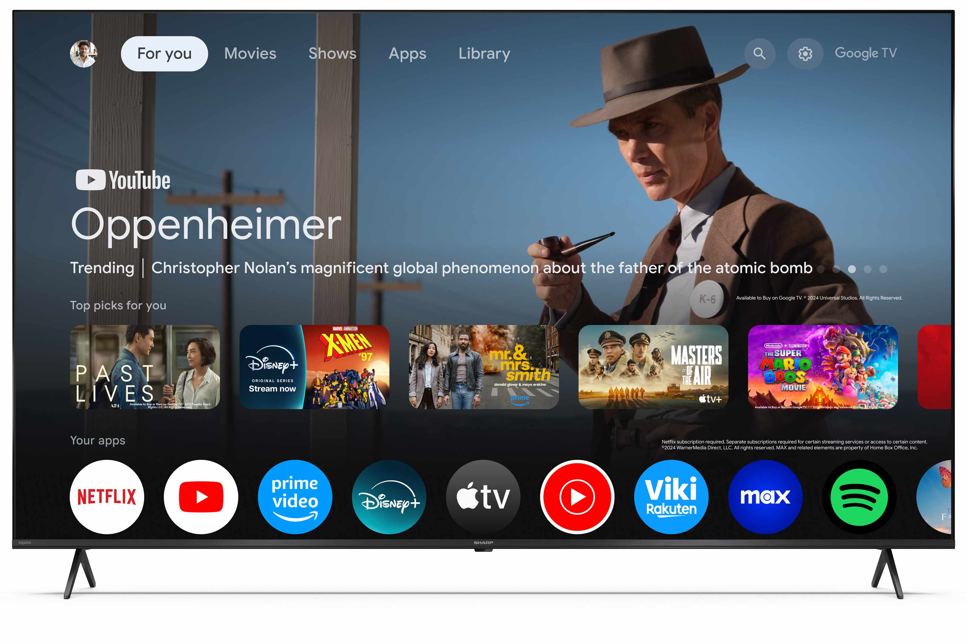 Ein Fernsehbildschirm zeigt ein Menü zur Filmauswahl mit dem hervorgehobenen Film Oppenheimer und mehreren Apps.
