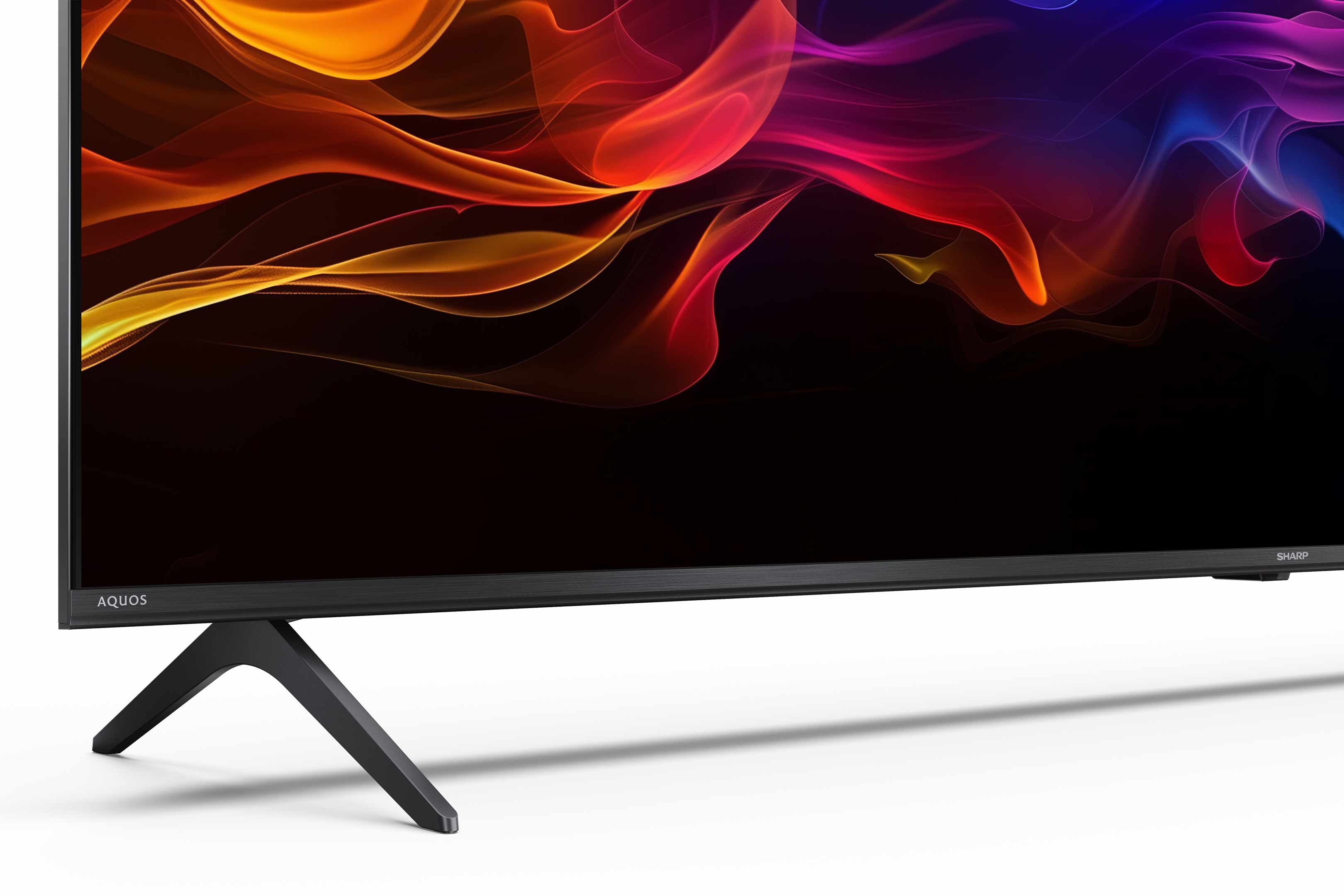 Ein Sharp Aquos Fernseher zeigt farbenfrohe, abstrakte Muster. Der Fernseher ist schwarz, mit schwarzem Ständer, auf weißem Hintergrund.