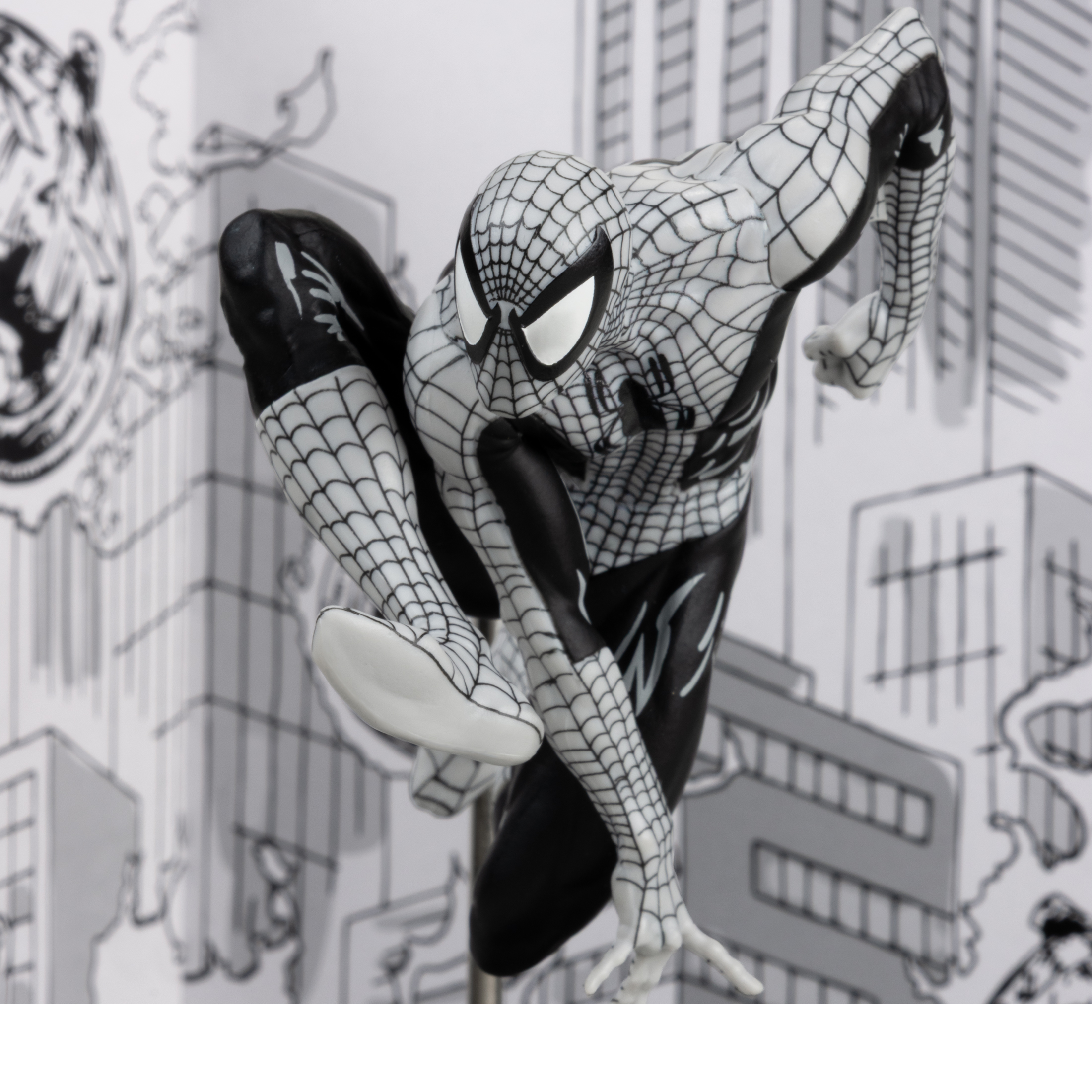 Una statuetta di Spider-Man in posa dinamica. È in bianco e nero, su uno sfondo di città abbozzata.