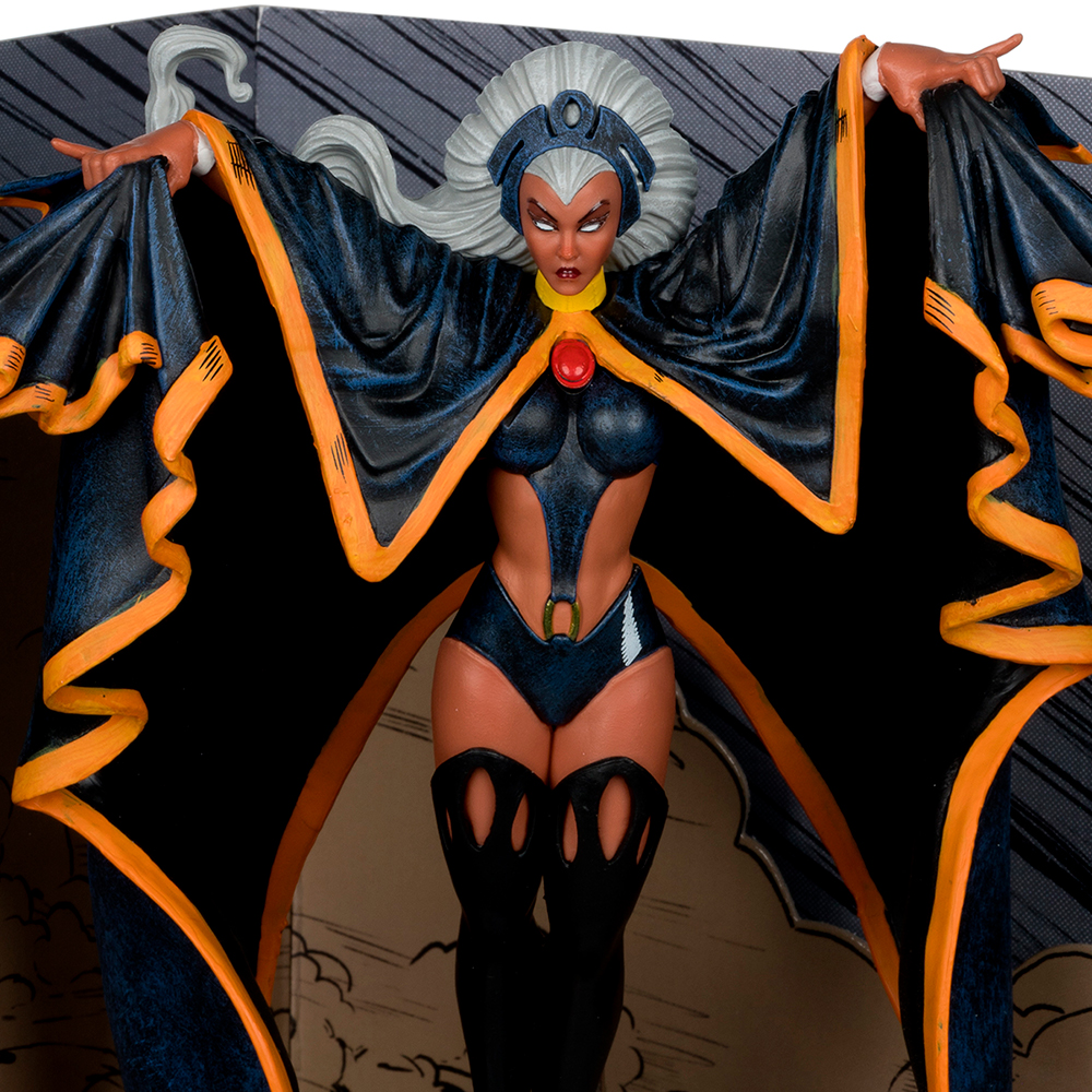 Eine Storm-Figur mit ausgestreckten Armen. Sie trägt einen schwarzen und orangenen Umhang, einen dunkelblauen Body und hat weißes Haar. Ihr Ausdruck ist streng.