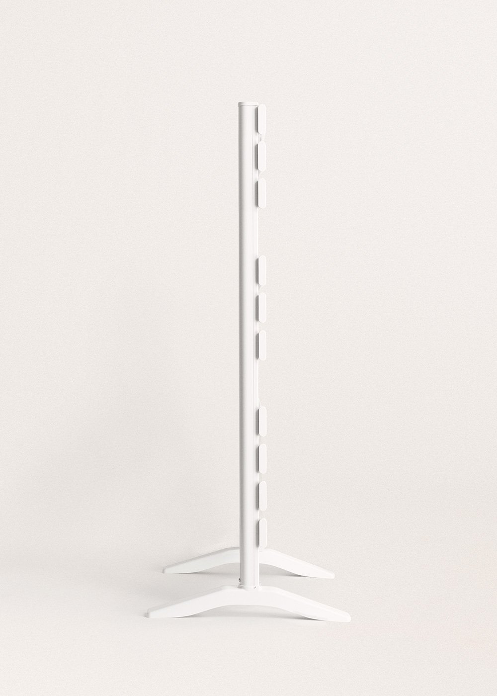 Un soporte blanco y vertical con parte superior e inferior rectangulares. Tiene varias ranuras rectangulares pequeñas y espaciadas uniformemente.